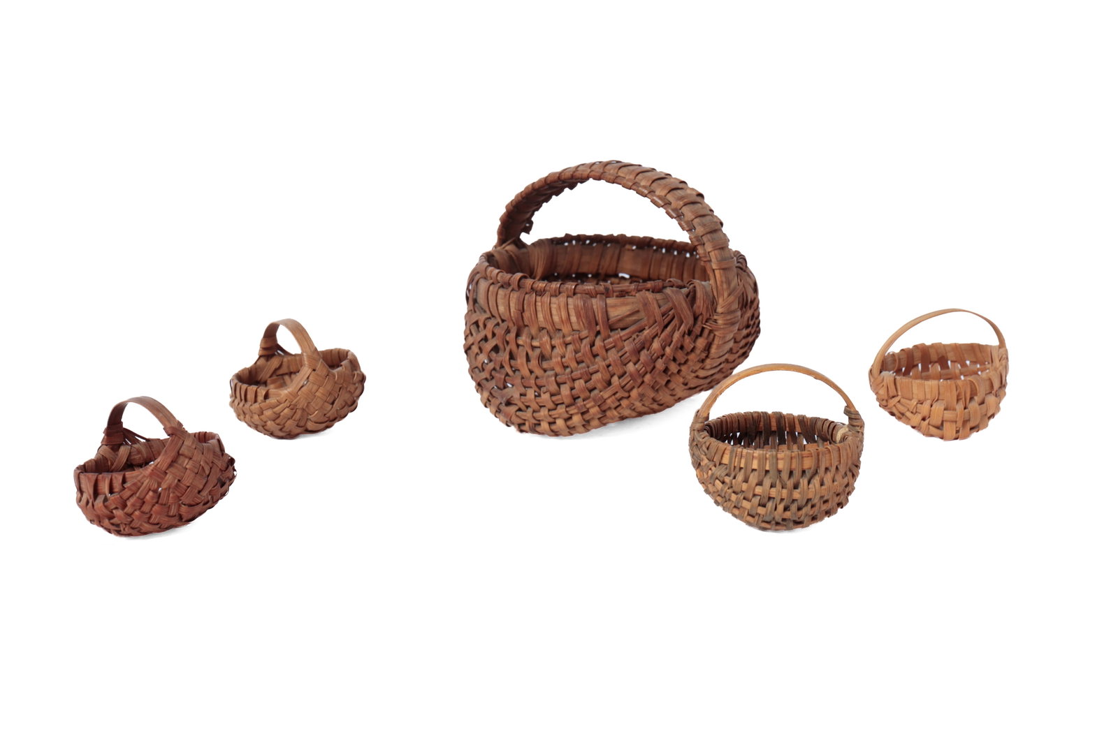 FIVE DIMINUTIVE AND MINIATURE WOVEN SPLINT BUTTOCKS BASKETS.: FIVE DIMINUTIVE AND MINIATURE WOVEN SPLINT BUTTOCKS BASKETS. American, 19th or 20th Century. The largest with an unusual wrapped handle, dark patina, wrapped rim, and a bentwood handle, 2.5”h.