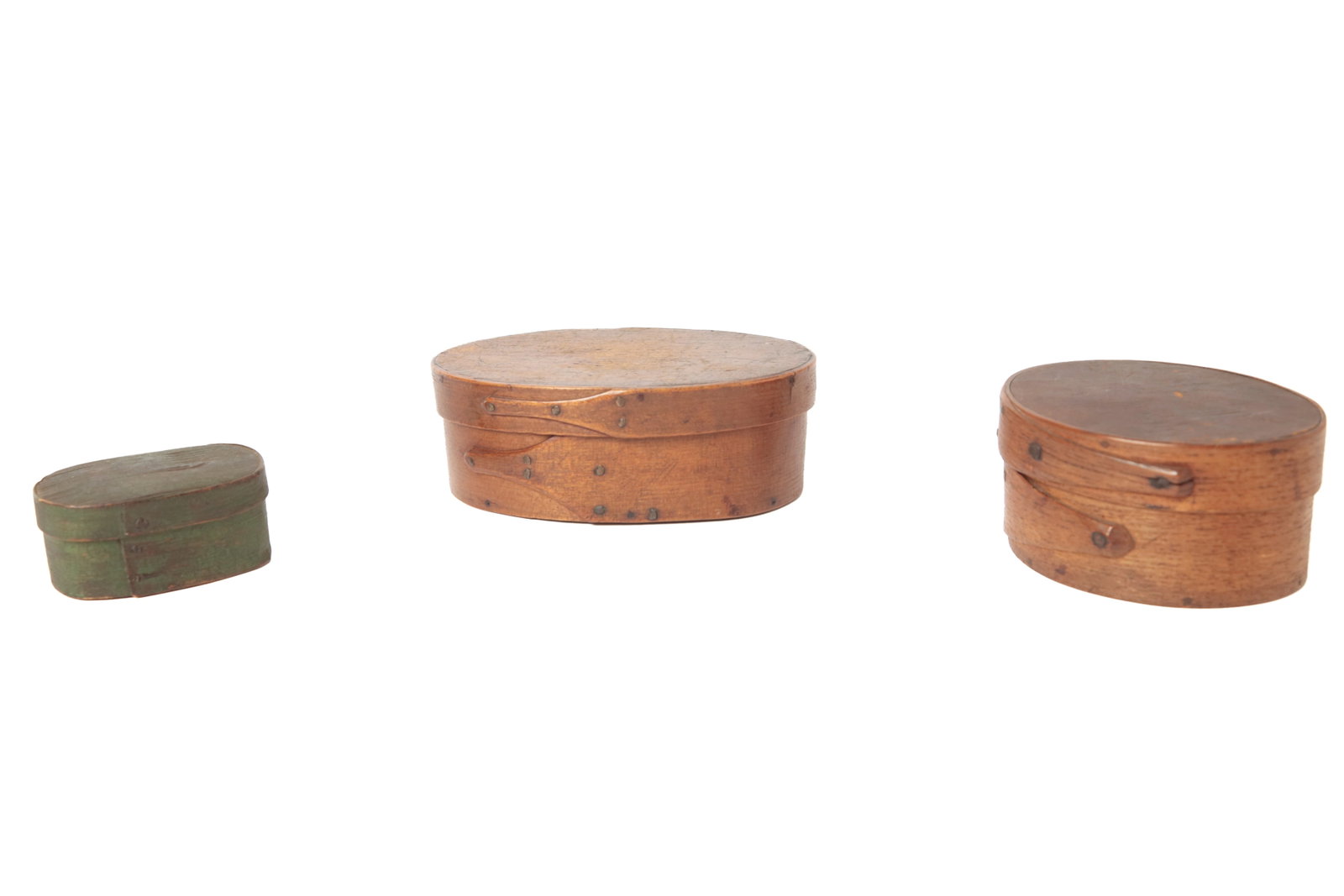 THREE OVAL PANTRY BOXES.: THREE OVAL PANTRY BOXES. American, 19th Century. The largest, a Shaker example in birch, pegged construction with copper tacks and two finger joints, 2"h. 5.75"w.; the second in original finish,