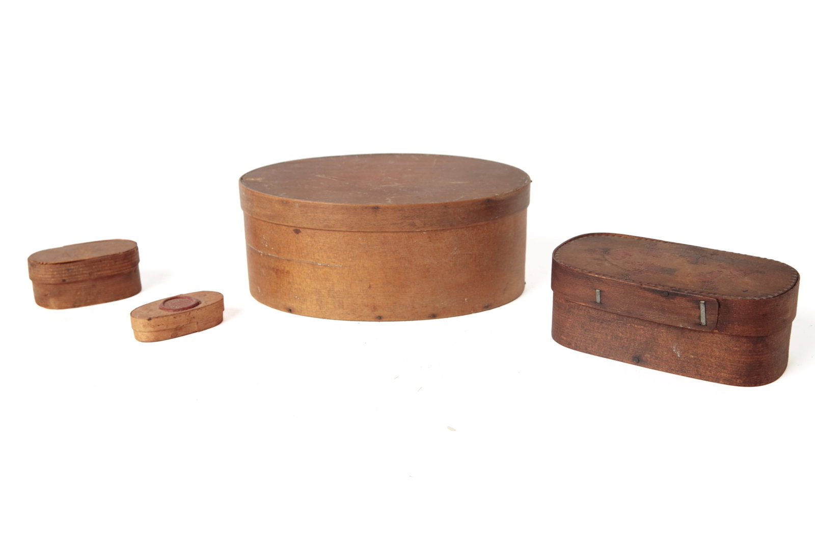 FOUR DIMINUTIVE BENTWOOD BOXES.: FOUR DIMINUTIVE BENTWOOD BOXES. American, second half 19th Century. Pine. A Shaker box with finger joints and copper tacks. 3"h. 7.25"w. One with chip carved floral lid, lap joints, and steel