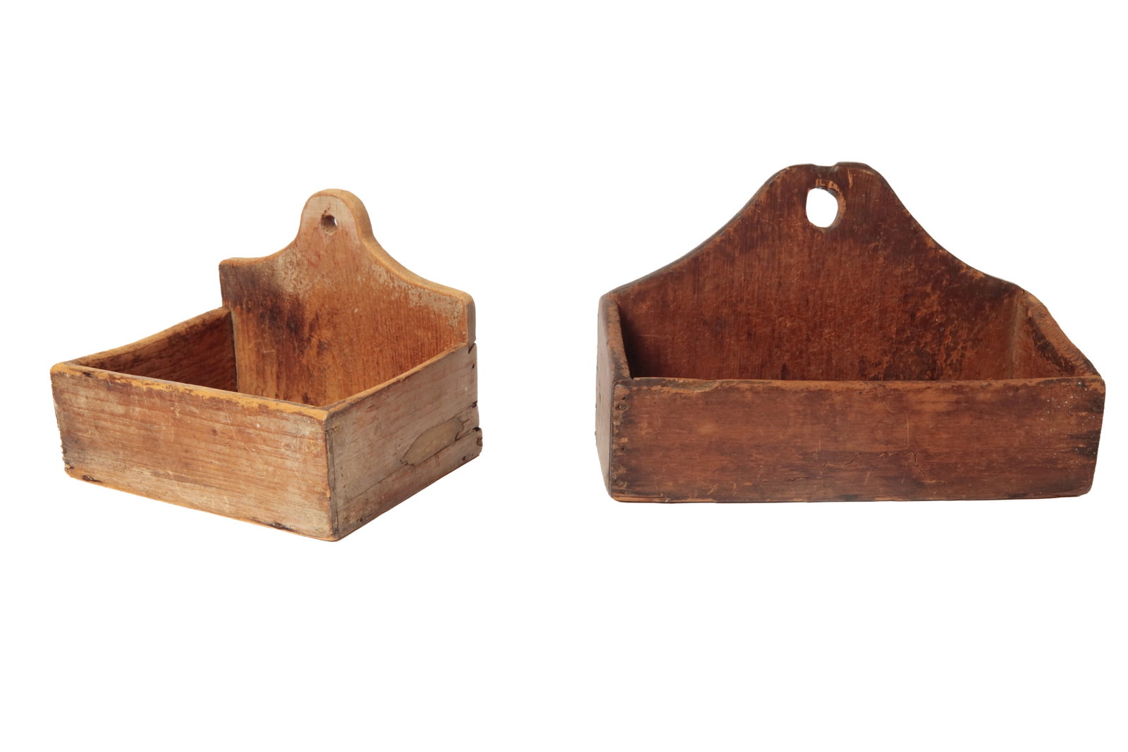 TWO HANGING CANDLE BOXES WITH ORIGINAL SURFACES.: TWO HANGING CANDLE BOXES WITH ORIGINAL SURFACES. American, 19th Century. Pine. One with a tombstone shaped back with traces of original white paint and square nail construction. 8.5"h. 10.5"w.