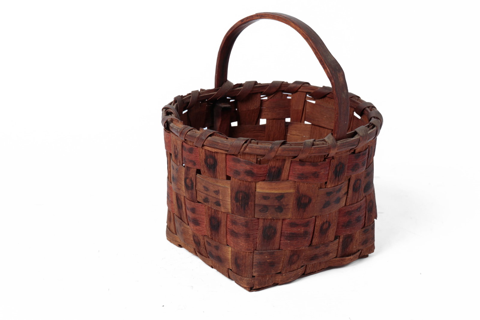 NATIVE AMERICAN POTATO STAMP DECORATED BASKET.: NATIVE AMERICAN POTATO STAMP DECORATED BASKET. American, early 20th Century. A basket in the round, with a wrapped rim, large woven splints, and a bentwood handle. Exterior decorated in dark potato st