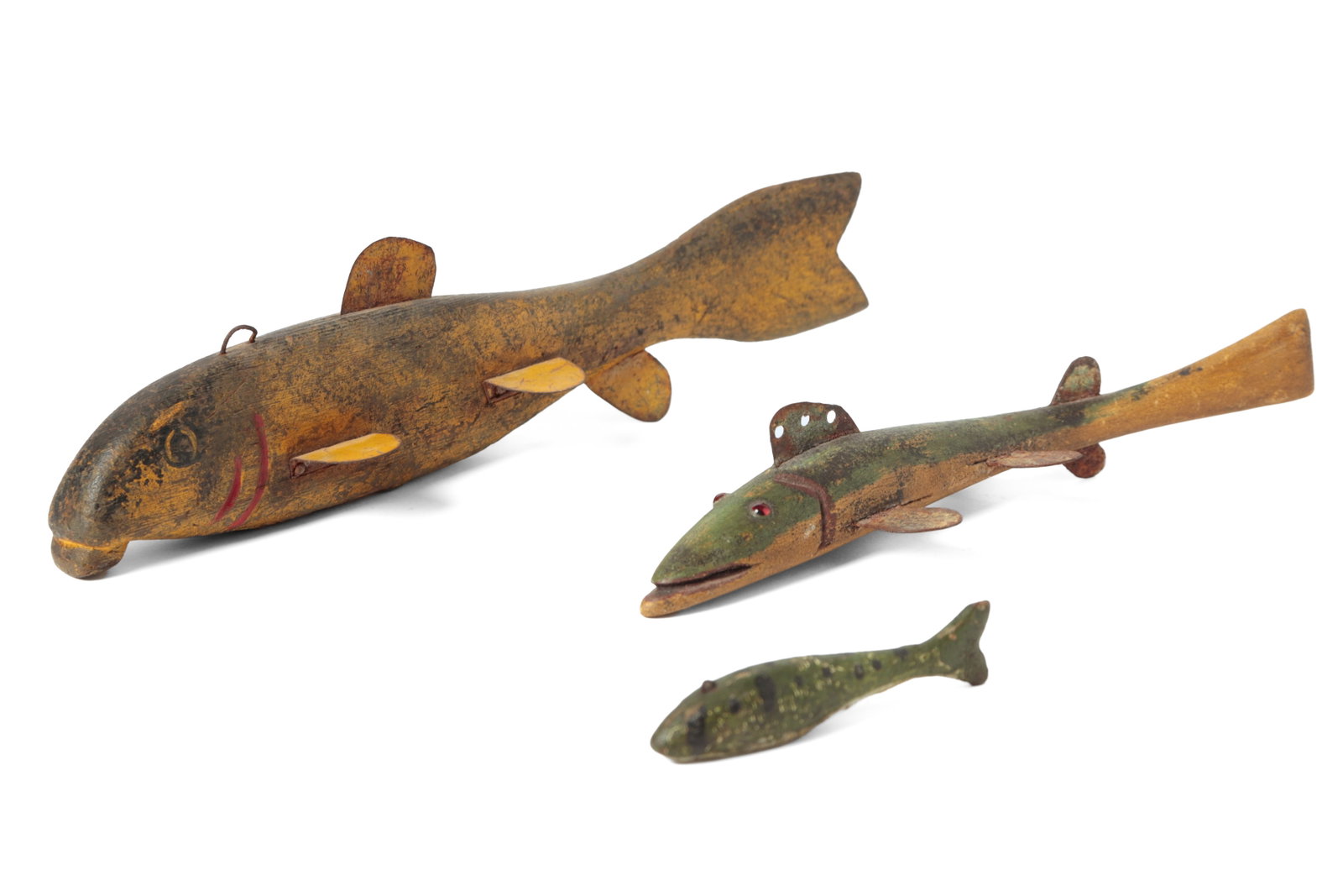 THREE FOLK ART CARVED AND PAINTED ICE FISHING DECOYS.: THREE FOLK ART CARVED AND PAINTED ICE FISHING DECOYS. American, 20th Century. A miniature baby perch in green with black spots and an inset weight at bottom, 0.75"h. 3.75"l., a thin curved fish with g