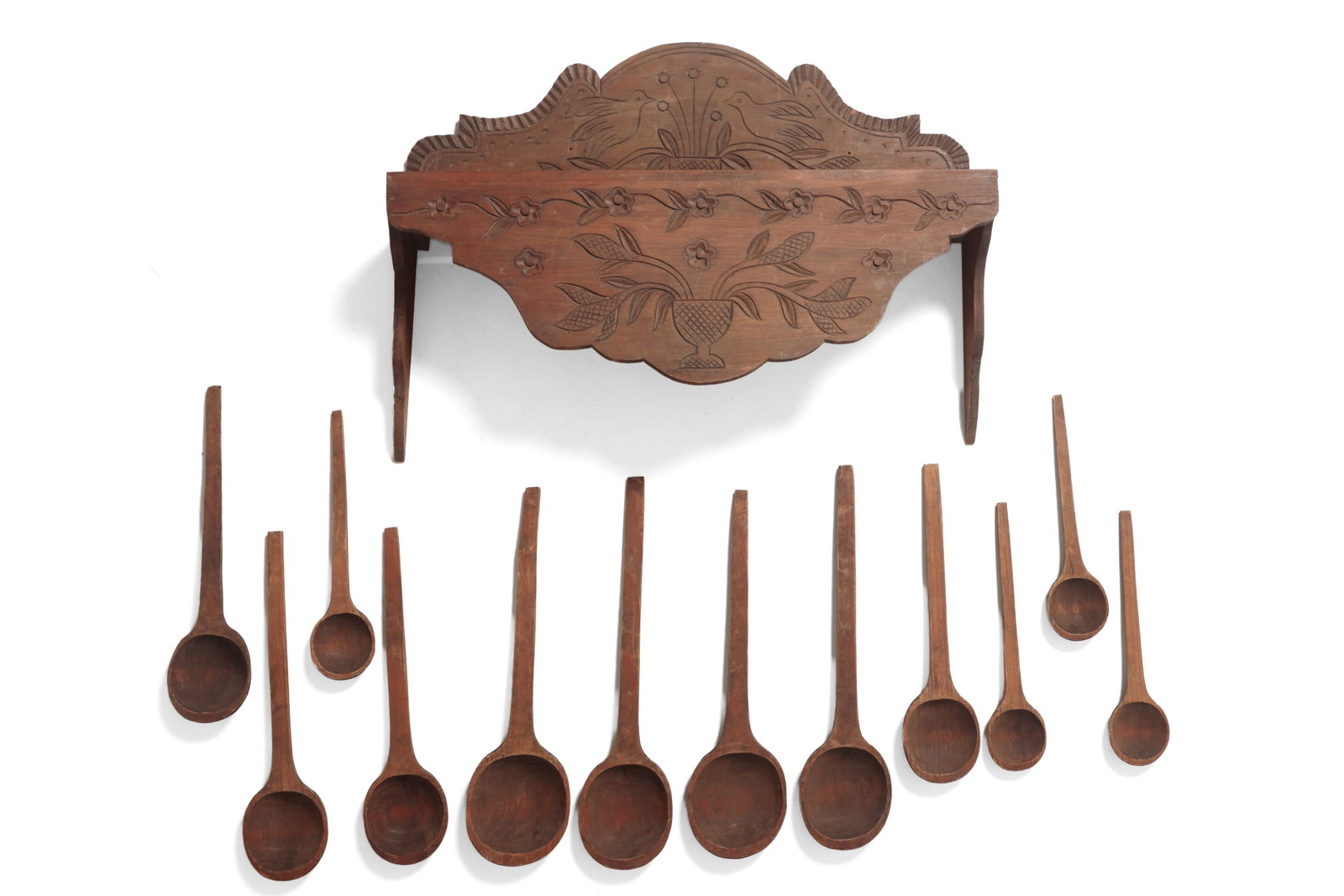 LARGE WALL-HANGING HAND-CARVED RACK WITH SPOONS.: LARGE WALL-HANGING HAND-CARVED RACK WITH SPOONS. American, late 19th or early 20th Century. Boldly scalloped crest with carved bird and urn decoration, three slots to the top, and scalloped drop