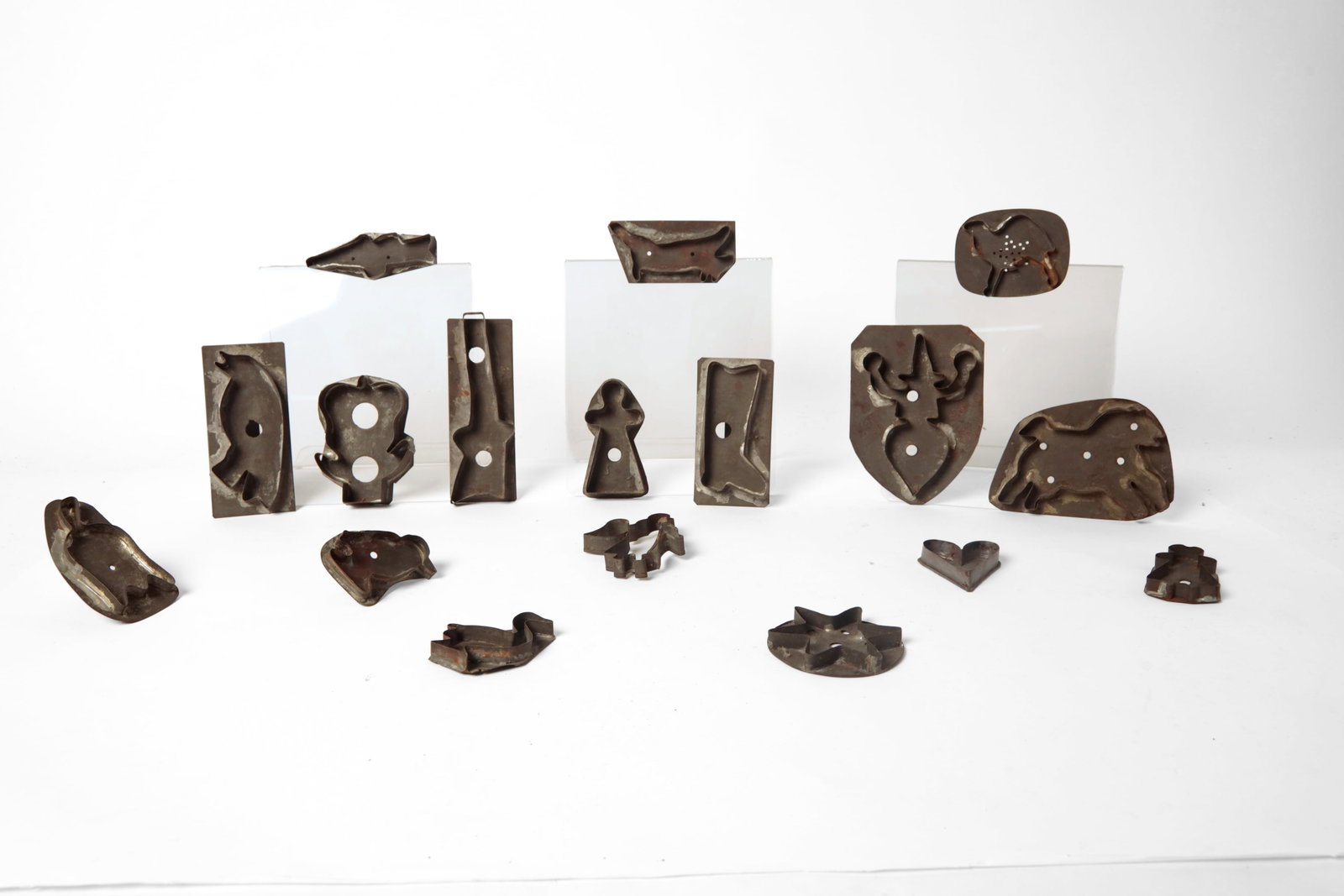 COLLECTION OF TINSMITH-MADE COOKIE CUTTERS.: COLLECTION OF TINSMITH-MADE COOKIE CUTTERS. American, late 19th Century. Included are a rifle, witch, birds, angel, tulips, heart, horse, camel and others. From 6.75"h. to 2.75"h. Provenance: From