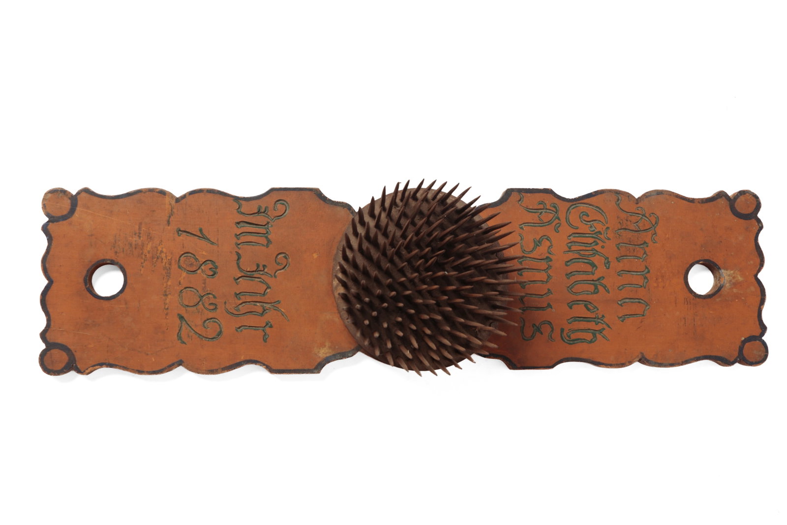 PAINT-DECORATED HATCHEL, DATED 1882.: PAINT-DECORATED HATCHEL, DATED 1882. German. Hardwood. Rectangular board with shaped sides, circular hatchel at center, and incised "Anna Elisabeth Asmus Imfrhr? 1882" in green paint. 3.75"h. 22.75"l.