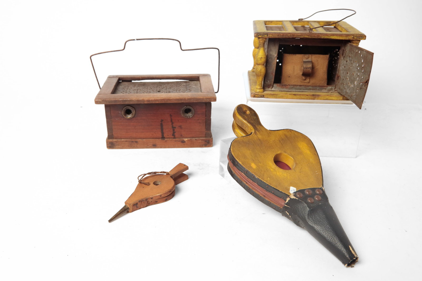TWO FOOT WARMERS AND TWO BELLOWS.: TWO FOOT WARMERS AND TWO BELLOWS. American, 19th and 20th Century. An unusual form, dovetailed wood and iron-lined footwarmer, with hinged lid, punched top, vents on the front and back, and a wire