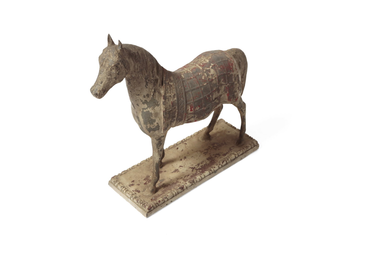 PAINTED METAL HORSE FIGURE.: PAINTED METAL HORSE FIGURE. American, late 19th or early 20th Century. A full-bodied horse, wearing a patterned blanket, with a long mane and tail and standing on a rectangular plinth. In worn paint.