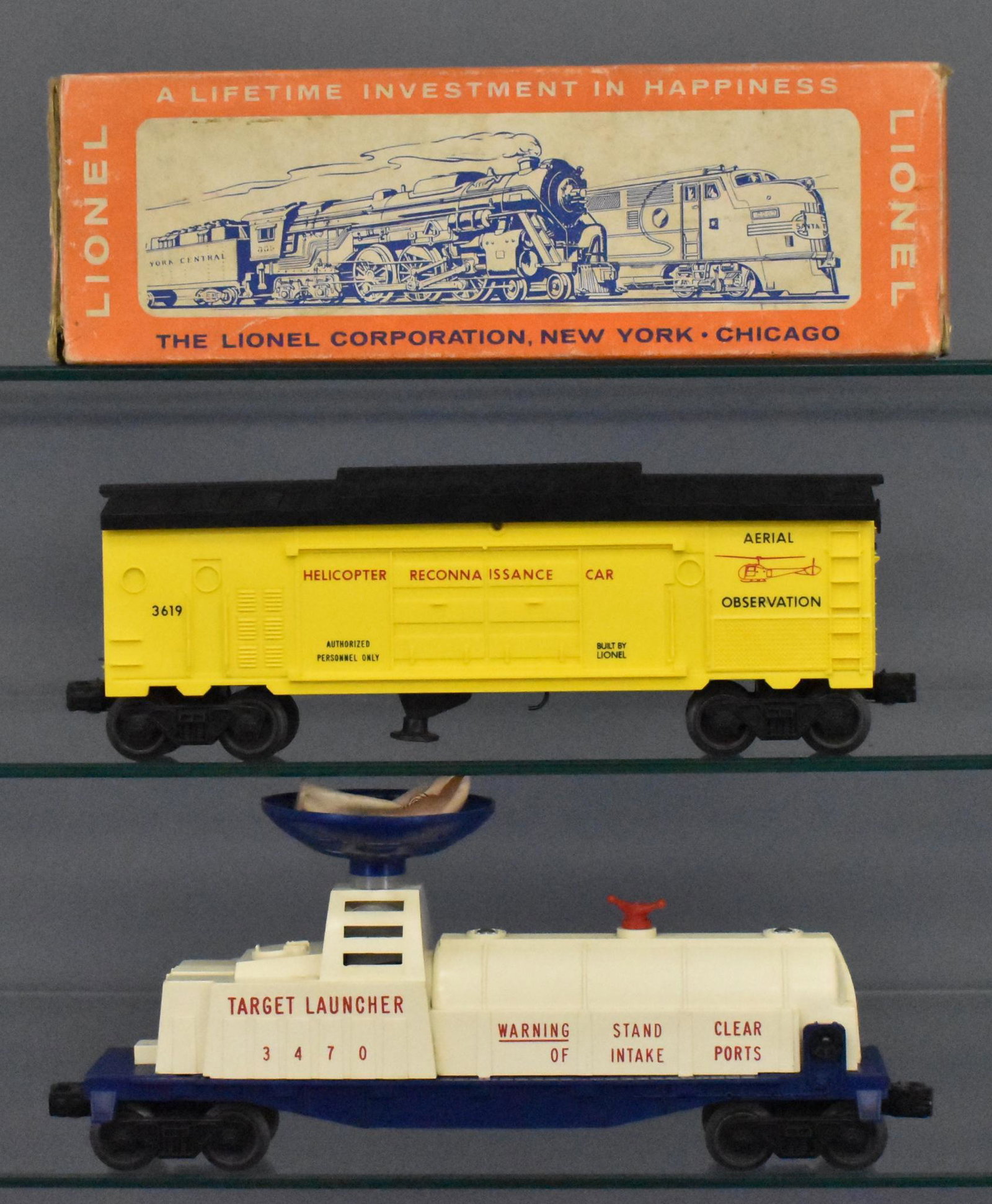 Lionel postwar O gauge 3619 and 3470 military cars with: Includes 3619 helicopter reconnaissance car that shows moderate run time but is clean, missing the red helicopter but otherwise C7. The 3470 aerial target launching car is unrun but C6-7 due to discol