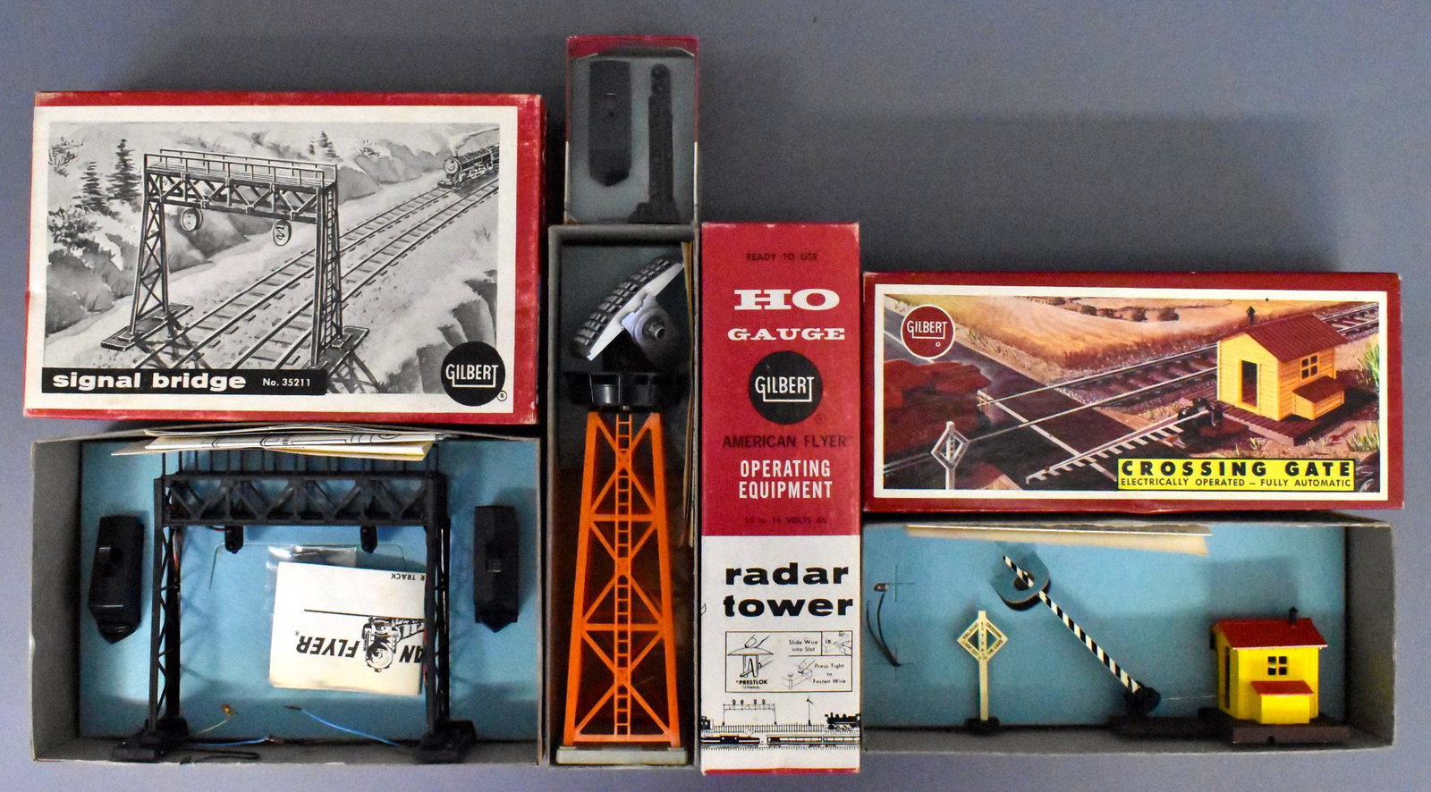 Four mint boxed Gilbert American Flyer HO accessories: Includes 35205 block signal, 35210 radar tower, 35211 signal bridge and 35212 crossing gate, all four are C9-10 with very good to excellent original boxes and all original paperwork.
