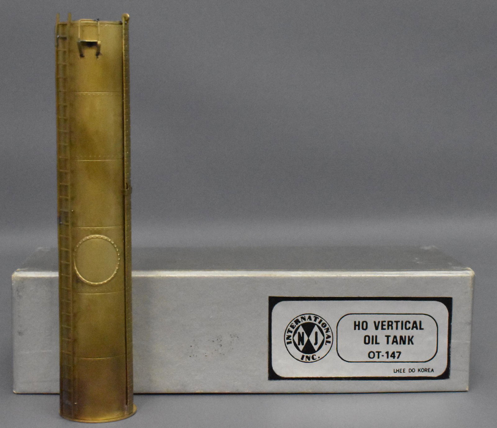 NJ International Inc. HO Scale Brass Vertical Oil Tank: Tank is C7 due to spots of toning, otherwise it is in excellent plus condition in a solid very good condtion box with light high corner wear.
