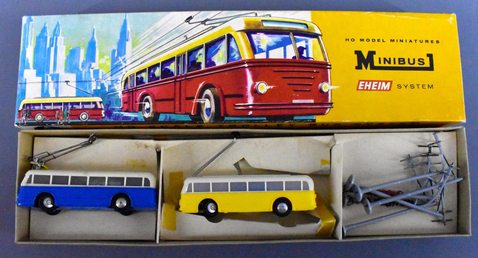AHM HO Scale Trolley Bus System in OB: AHM HO Scale Trolley Bus System in original box. Set is open and may have been lightly used, it has both a yellow and a blue trolley that look very clean, has 6 poles and metal conducting rods. Box is