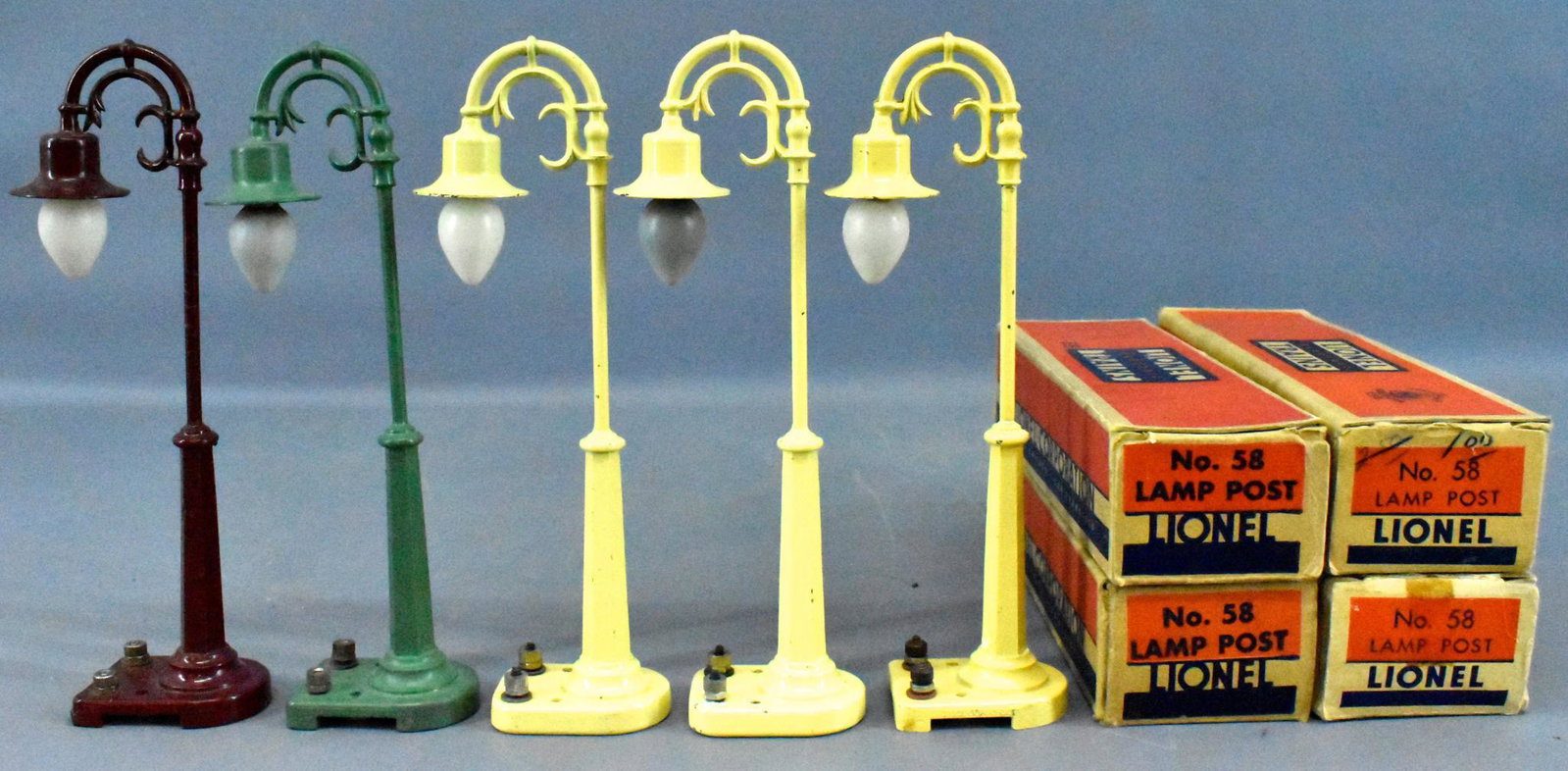 Five Lionel prewar and postwar O gauge 58 lamp posts: Five Lionel prewar and postwar O gauge 58 lamp posts with four original boxes. Includes three yellow, one maroon and one peacock blue, C7 to C7+ with four good to very good original boxes.