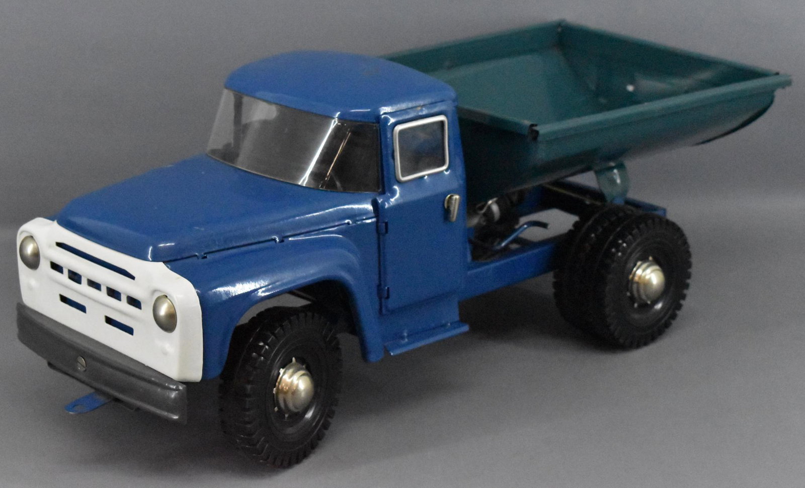1990's USSR Russian pressed steel dump truck: 1990's Russian pressed steel dump truck, hydraulic dump bed, works perfectly but has some scratches here and there, measures 21" long.