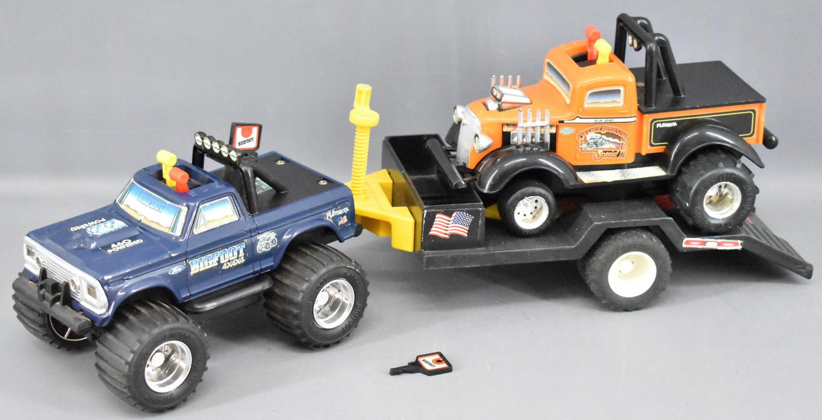 Group of Playskool SST trucks and trailer Bigfoot 4x4x4: Group of Playskool SST trucks and trailer to include a Bigfoot 4x4x4 with two keys that has been tested and works, Orange Blossom pulling truck that does not work and a flat bed trailer.