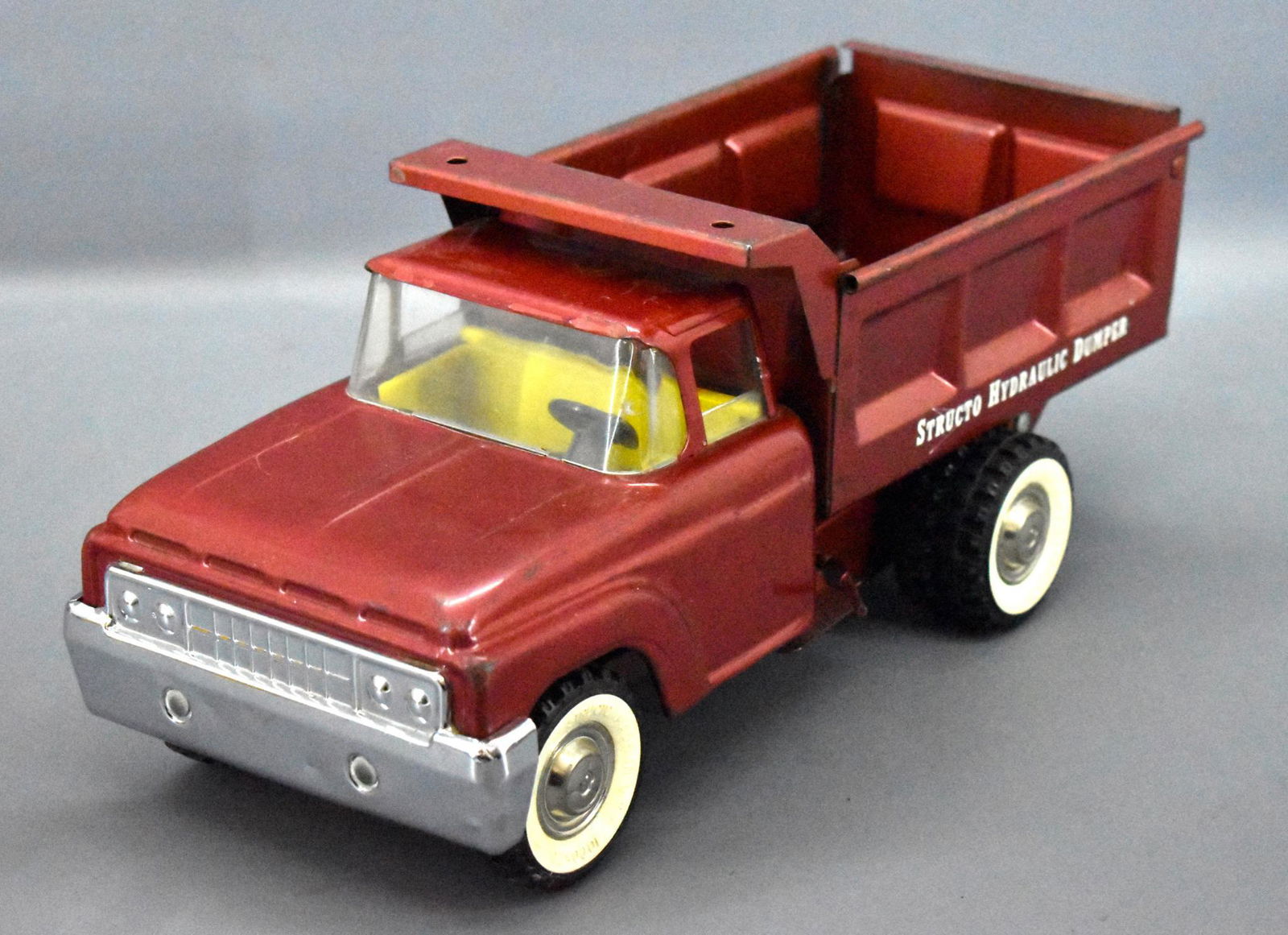 Structo pressed steel hydraulic dump truck: Structo pressed steel hydraulic dump truck, looks nice but has some touch ups on the roof and the cylinder works but sometimes the rod comes out of the end and has to be put back in.