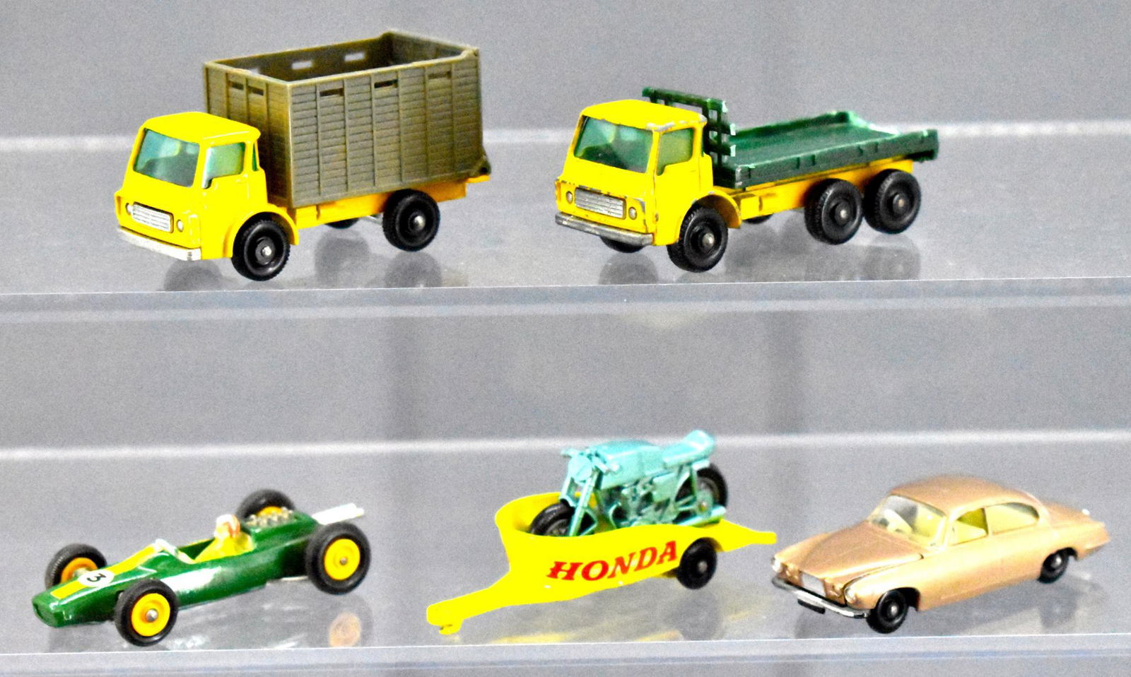 Group of five Lesney Matchbox loose: Group includes Jaguar MK10, No 38 Honda Motorcycle Trailer, No 37 Cattle Truck, No 19 Lotus, No 4 Stake Truck. All are in good condition with light wear in spots, other than the stake truck, it has ch