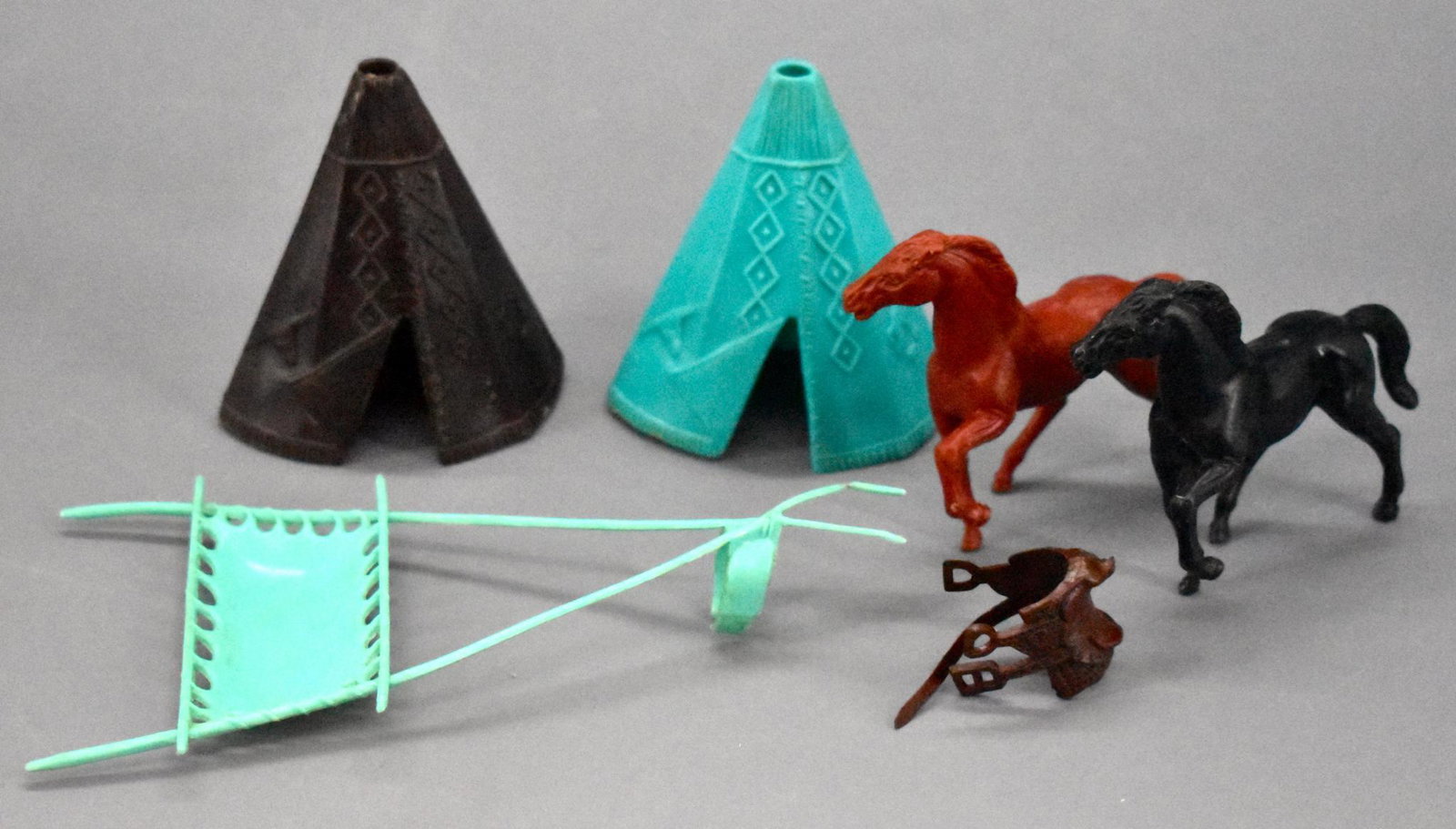 Stuart plastic horses Travois and teepees: Stuart plastic horses travois and teepees. includes two nice horses, a travois thatbis in nice shape, two teepees that are missing the tops and a rubber saddle.