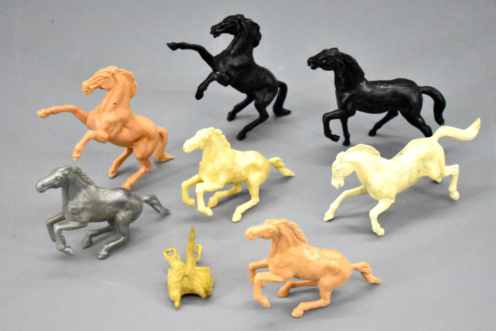 Seven Stuart plastic horses with one saddle: Seven Stuart plastic horses with one saddle, nice shape but have been played with.