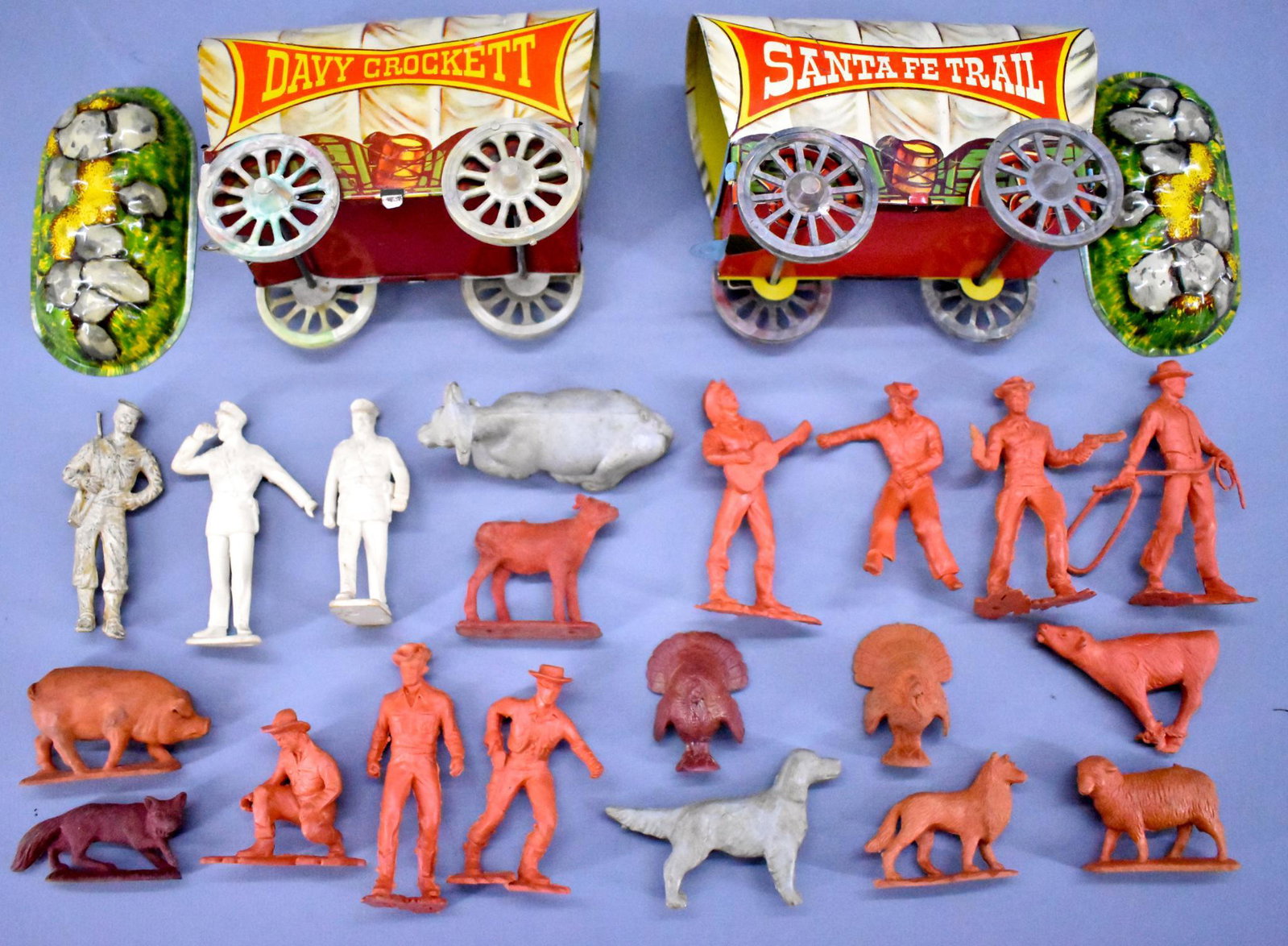 Group of Auburn vinyl cowboy and farm figures plus Davy: Group of Auburn vinyl cowboy and farm figures plus two US Metal Toy Mfg Co tin lithographed wagons with plastic wheels to include one Davy Crockett and one Santa Fe Trail, all in very good to excellen