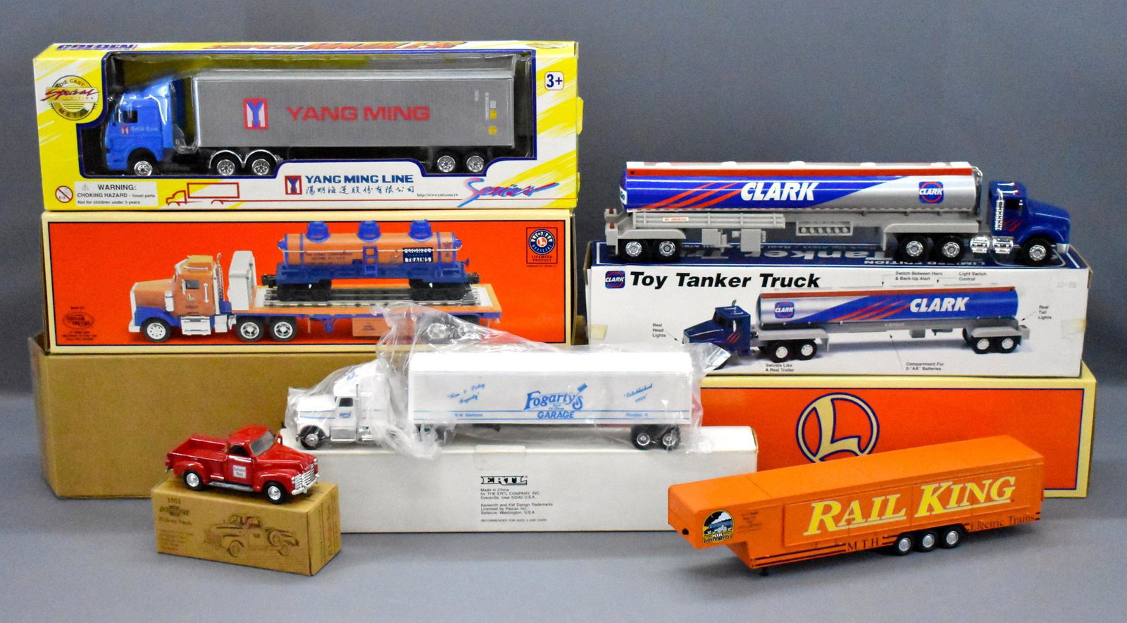 Group of die cast trucks in original boxes Lionel Ertl: Group of O gaugedie cast trucks in original boxes to include Lionel TMT-18410, TMT-18126, Clark toy tanker truck, Golden Whel die cast Yang Ming super hauler, Ertl Fogarty's garage semi tractor traile
