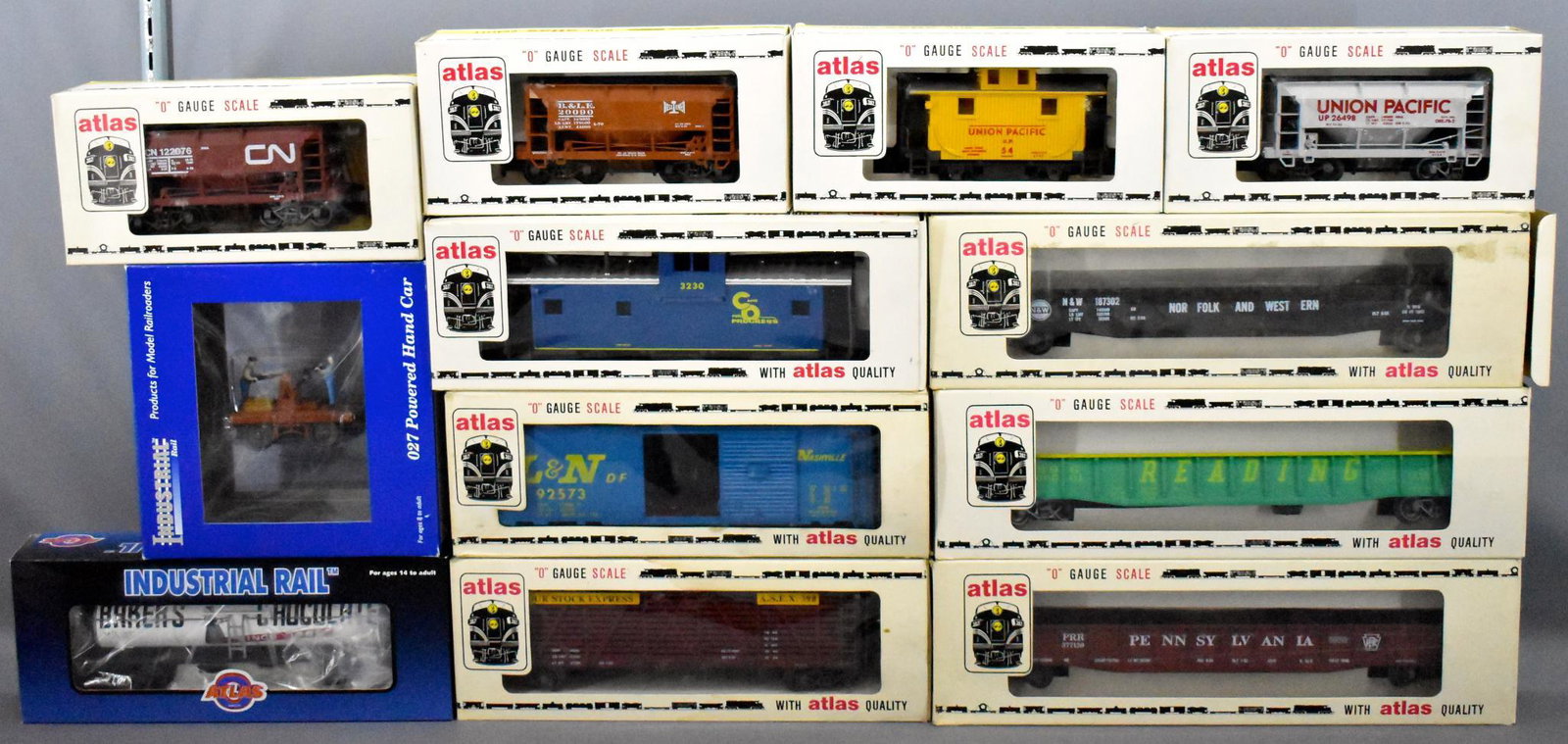 Group of Atlas and Industrial O gauge trains and: Group of Atlas and Industrial o gauge trains and freight cars in original boxes to include an O27 powered hand car and 11 various freight cars, C7-8 in very good to excellent original boxes. May have 