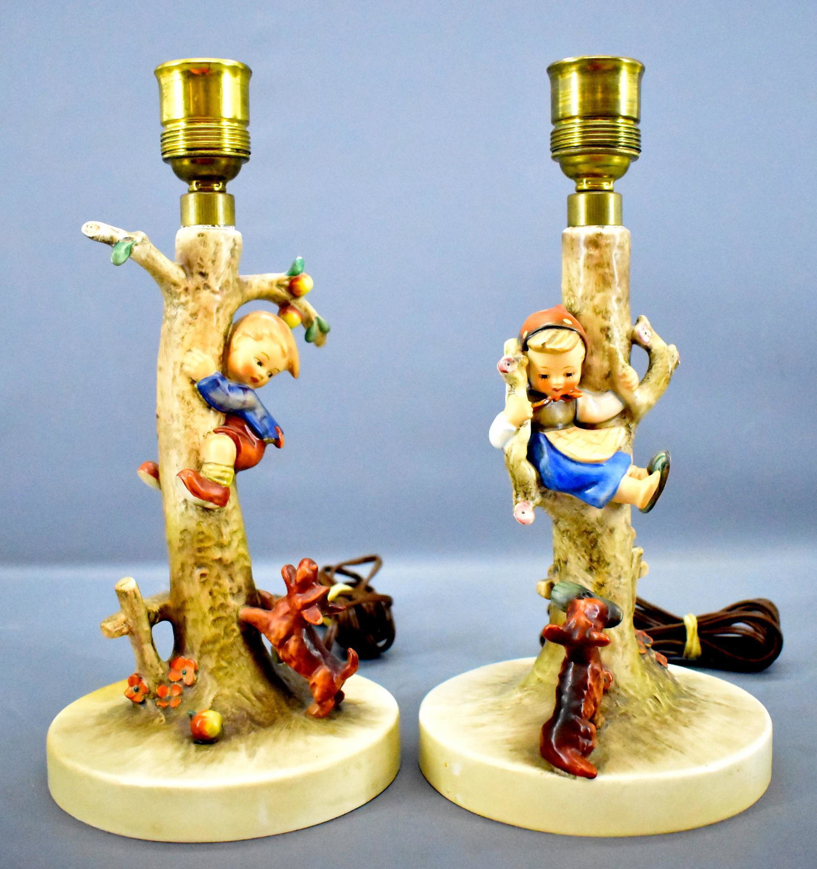 Hummel Out of Danger and Culprits electric lamp set: Hummel Out of Danger and Culprits electric lamp set. Each lamp has a child that has been treed by a dog, one boy and one girl. There is a tiny chip on the bottom of the base of the lamp with a boy, th