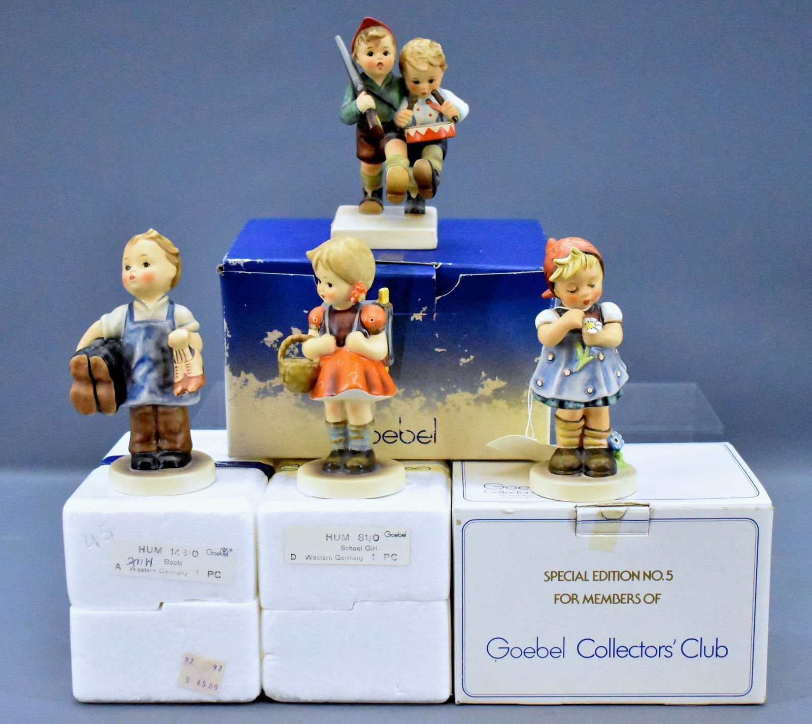 Four boxed Goebel Hummel figurines 81/0 50 2/0 143/0: Four boxed Goebel Hummel figurines to include 81/0 School Girl, 50 2/0 Volunteers, 143/0 Boots and 380 Daisies DonÃ¯Â¿½t Tell. All near mint with two original boxes with original inserts an