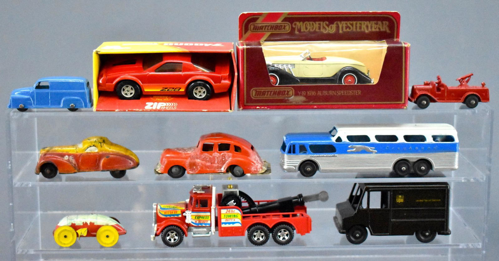 Group of modern and vintage die cast cars and trucks: Group of modern and vintage die cast cars and trucks to include UPS truck, Greyhound bus, unused Buddy L Camaro, Matchbox MOY, Majorette semi tow truck, Sun rubber car and more as seen in the photos.
