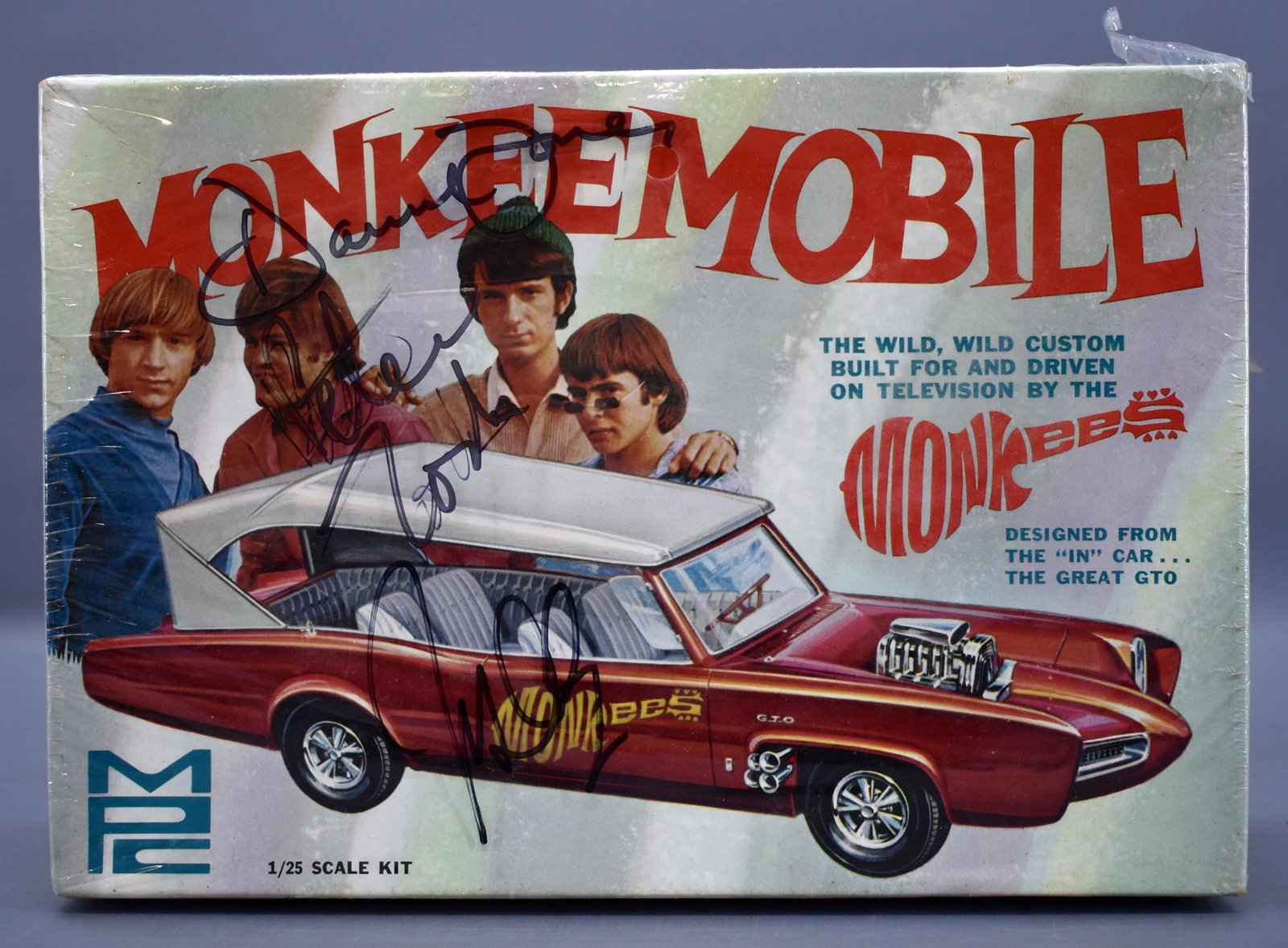Factory sealed AUTOGRAPHED MPC Monkeemobile Pontiac GTO: Original factory sealed AUTOGRAPHED MPC Monkeemobile Pontiac GTO 1/25 scale model kit No. 605. Kit is sealed with two small tears and was autographed by Peter Tork, Davey Jones and Mickey Dolenz follo