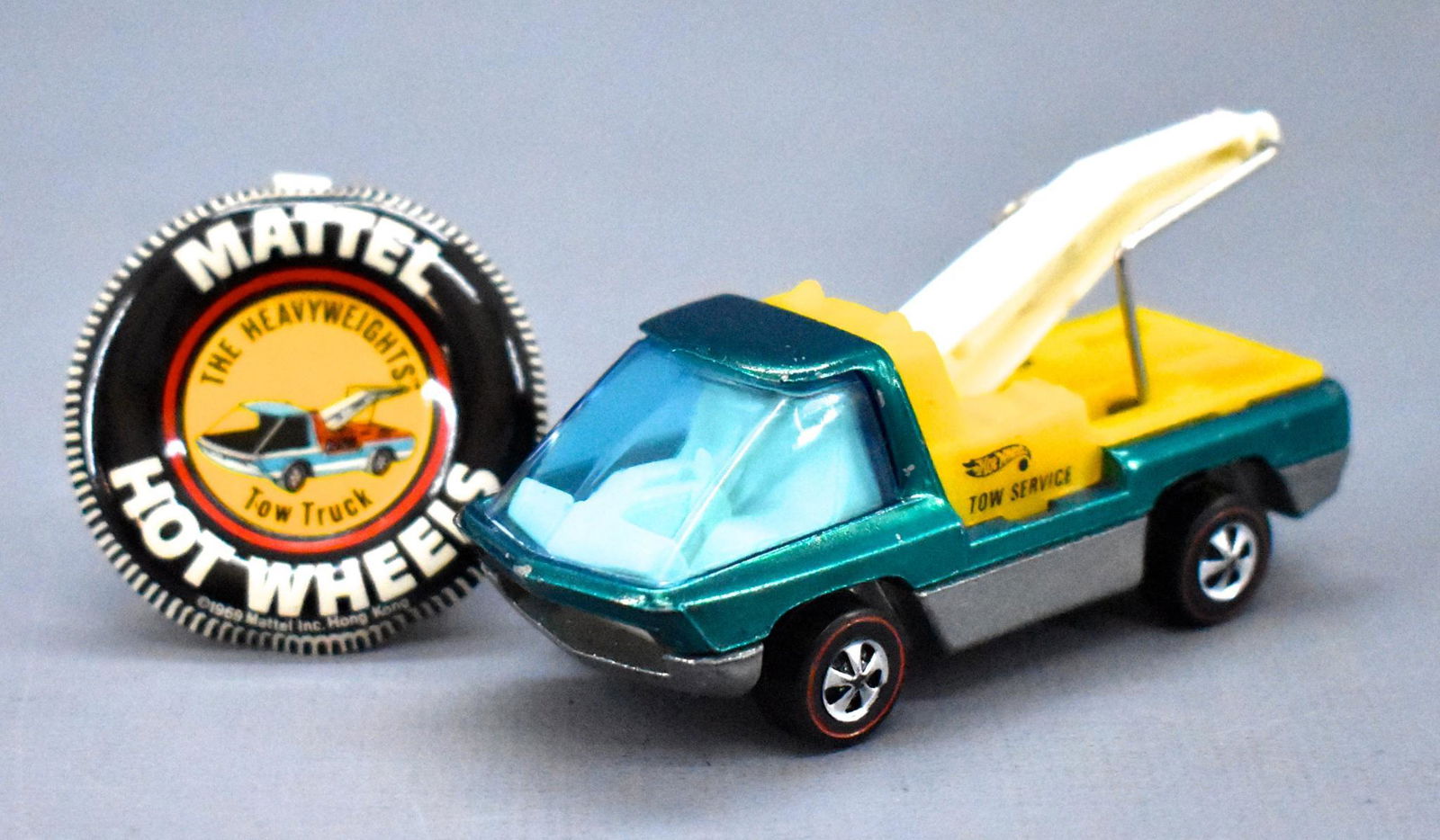 Redline Hot Wheels Heavyweights aqua HK Tow Truck with: Redline Hot Wheels Heavyweights aqua HK Tow Truck with original button, very nice with scattered tiny paint chips but very clean with a shiny gunmetal base.