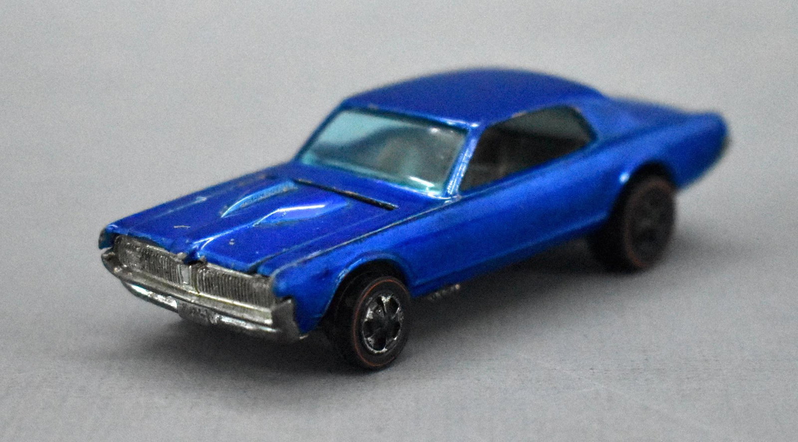 Redline Hot Wheels blue HK Custom Cougar: Redline Hot Wheels blue HK Custom Cougar, clean and shiny car with chrome loss from the wheels, paint and play wear. The base is painted silver with some wear as seen in the photos.