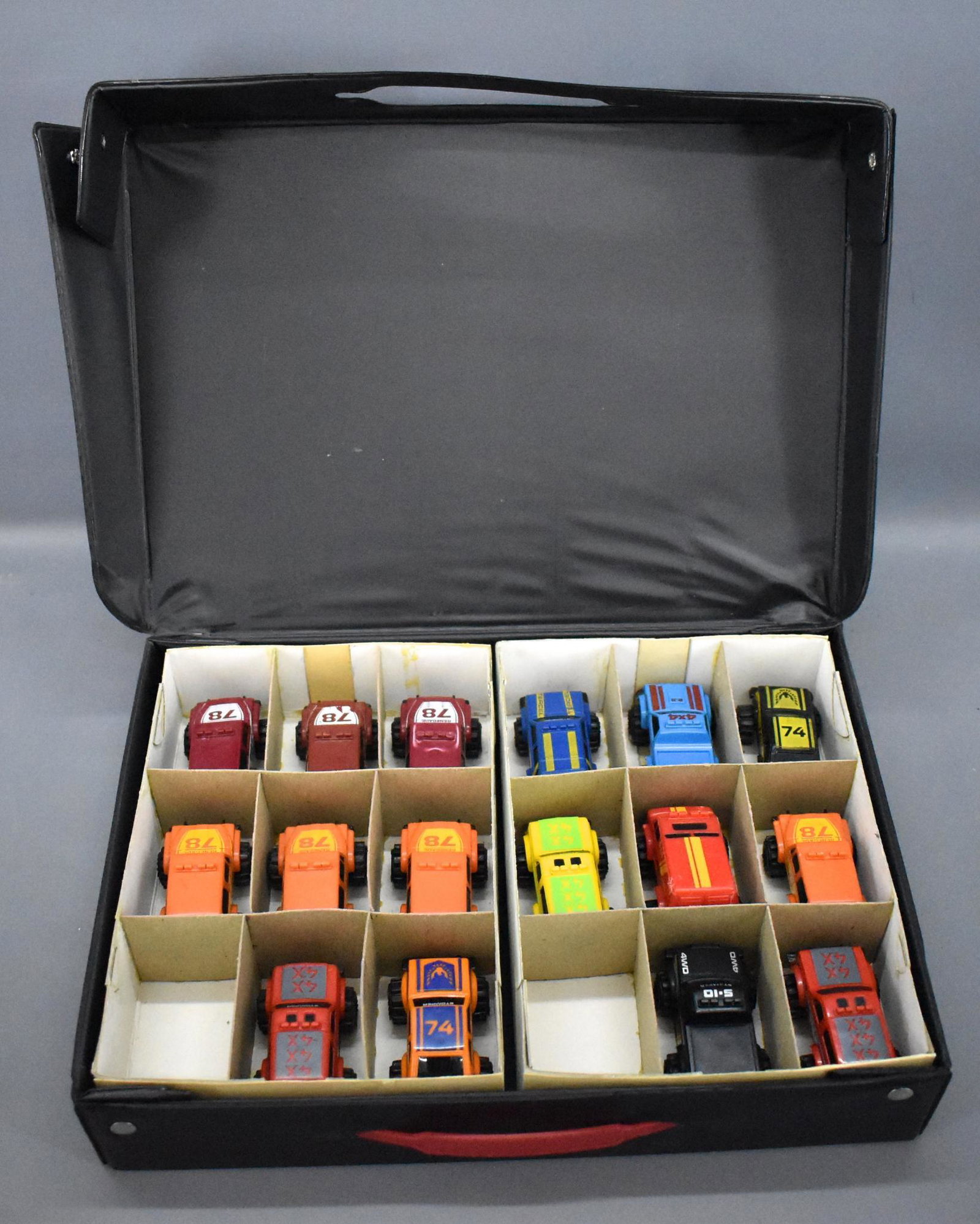 Schaper Stomper collectors case with 16 miniature: Schaper Stomper collectors case with 16 miniature Stompers that may have damage, most are dirty and need to be cleaned and some show play wear on the bottoms. The case is dirty and one rivet has pulle