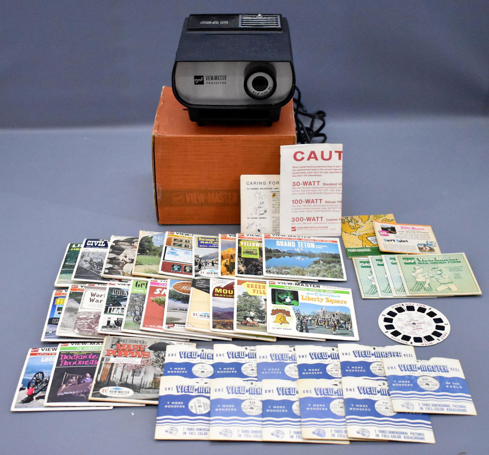 Viewmaster 100 deluxe Projector in original box plus: Viewmaster 100 deluxe Projector in original box plus lots of reel sets. All of the reels are in good to excellent condition, some still have good color and some are sepia, the projector is in excellen