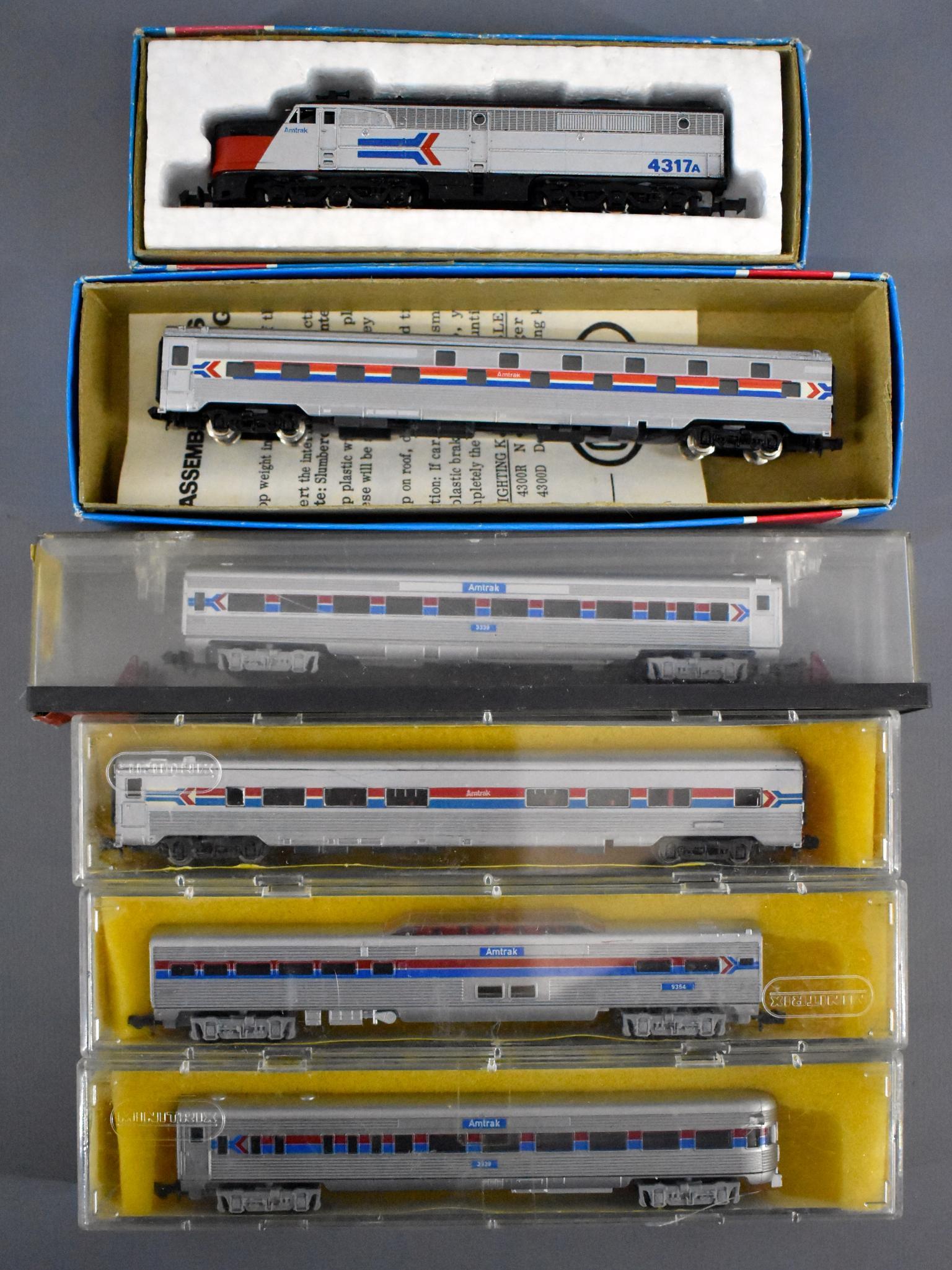 Mixed N gauge Amtrak diesel passenger set in original: Mixed N gauge Amtrak diesel passenger set in original boxes to include Con Cor PA-1 powered diesel locomotive and slumbercoach car, three Minitrix and one MRC passenger cars in fair to excellent origi