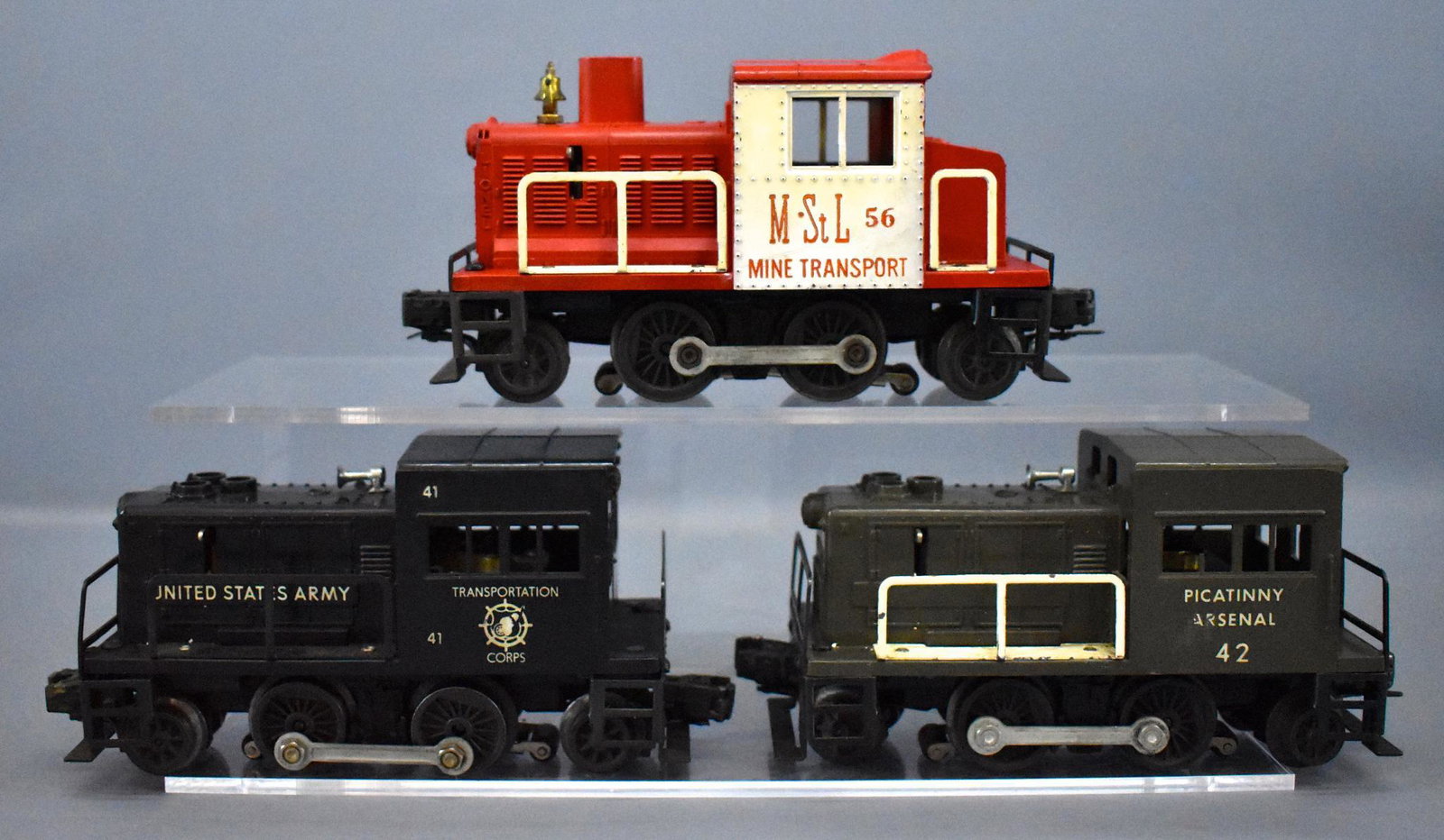 Group of three Lionel postwar O gauge switchers: Group of three Lionel postwar O gauge Switchers, group includes 41 US Army in good condition with no cracks or breaks, a 42 Picatinny Arsenal with a cracked window strut and 56 Minneapolis & St. Louis