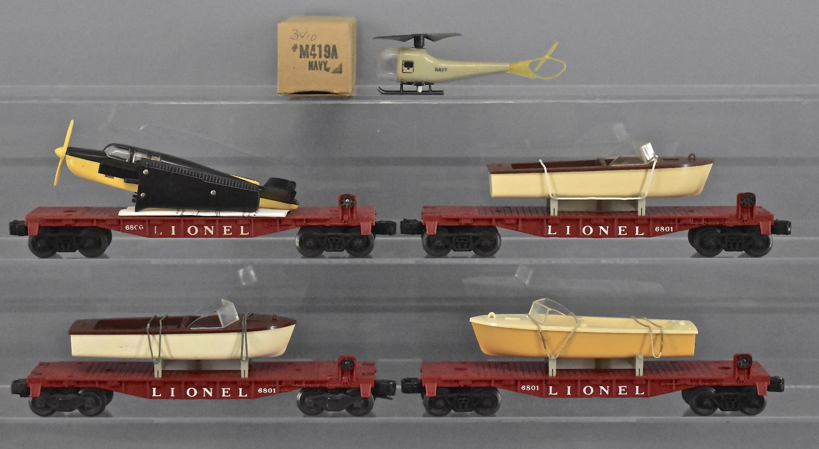 Group of four Lionel postwar O gauge flat cars: Group of four Lionel postwar O gauge vehicle flat cars, group includes a 6800 plane flat car with a reproduction plane, three 6801 Flat cars with boats, both brown boats are reproductions the yellow b