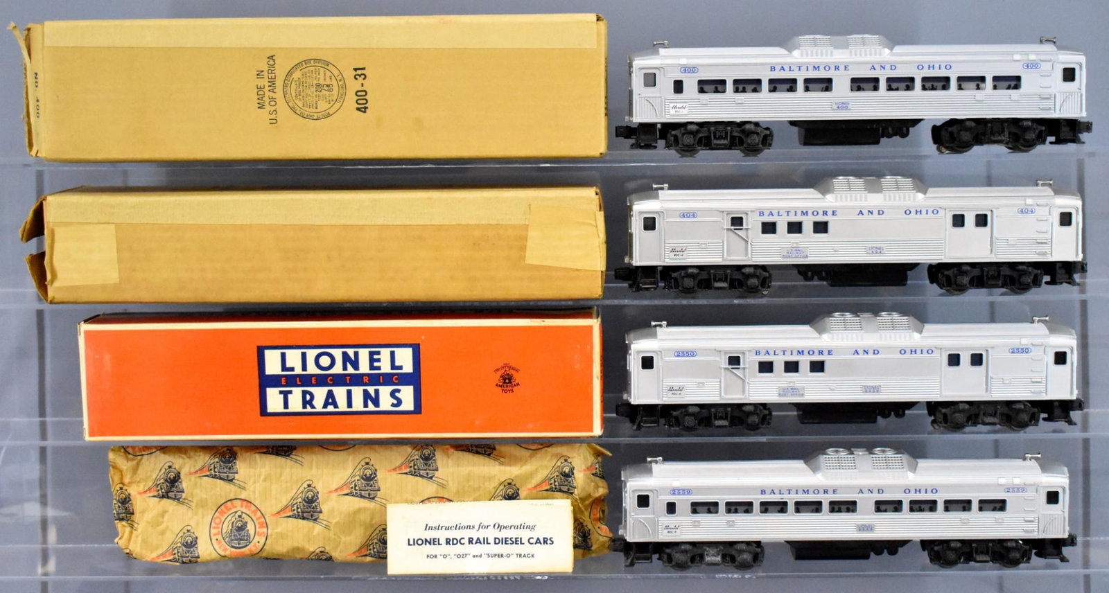 Lionel postwar O gauge Budd car set with three original: Lionel postwar O gauge Budd car set with three original boxes to include powered 400 and 404 units plus non-powered 2550 and 2559 cars. These all show moderate run time and are C7 with three good to e