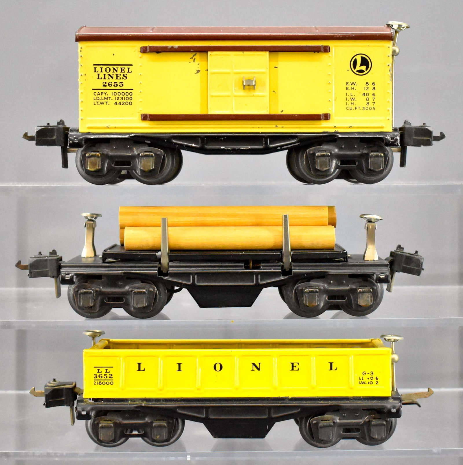 Three Lionel prewar O gauge 2600 series matching: Three Lionel prewar O gauge 2600 series matching coupler freight cars to include 2655 box car, 3652 operating gondola operating barrel dump car (missing part of coupler) and 3651 automatic log dump ca