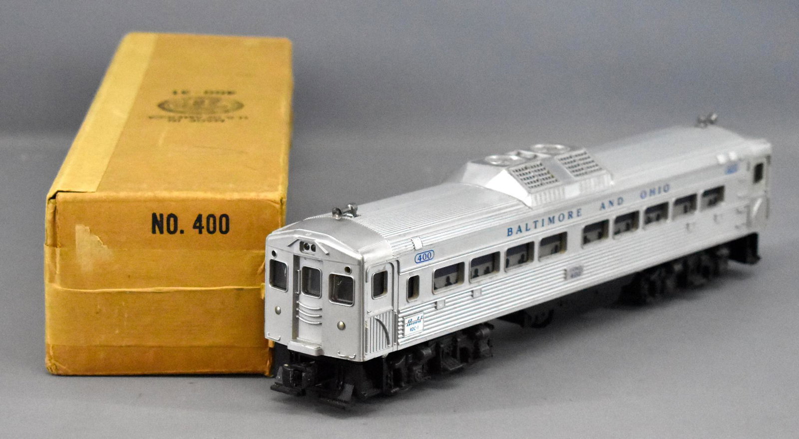 Lionel postwar O 400 Budd B&O powered car in original: Lionel postwar O 400 Budd powered car in original box, car shows very light run time and is C7 in a nice original box that has graffiti on most of the sides as seen in the photos.