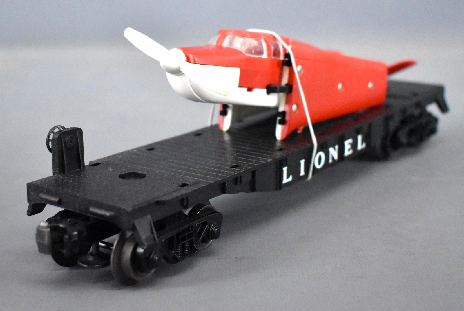 Lionel postwar O 6500 flat car with red over white: Lionel postwar O 6500 flat car with red over white Beechcraft Bonanza airplane. Car is C8 with very light run time, the airplane is all original with heat stamped lettering and is clearly marked on th