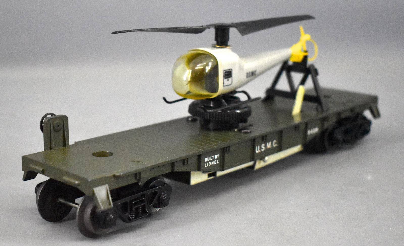 Unrun Lionel olive drab postwar O 3429 USMC operating: Unrun Lionel postwar O 3429 USMC operating helicopter car, car is C8 but only due to a tiny paint flake on the flat car that exposes the original blue molded car, otherwise a fantastic piece with an a