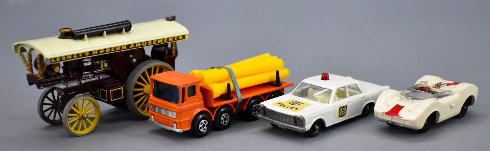 Four vintage Matchbox and Aurora die cast cars: Four vintage Matchbox and Aurora die cast cars. Includes an orange transitional Superfast ergomatic cab with variation yellow pipes, 55/59 Ford Galaxie police car, MOY 9 Fowler's showman's engine and 