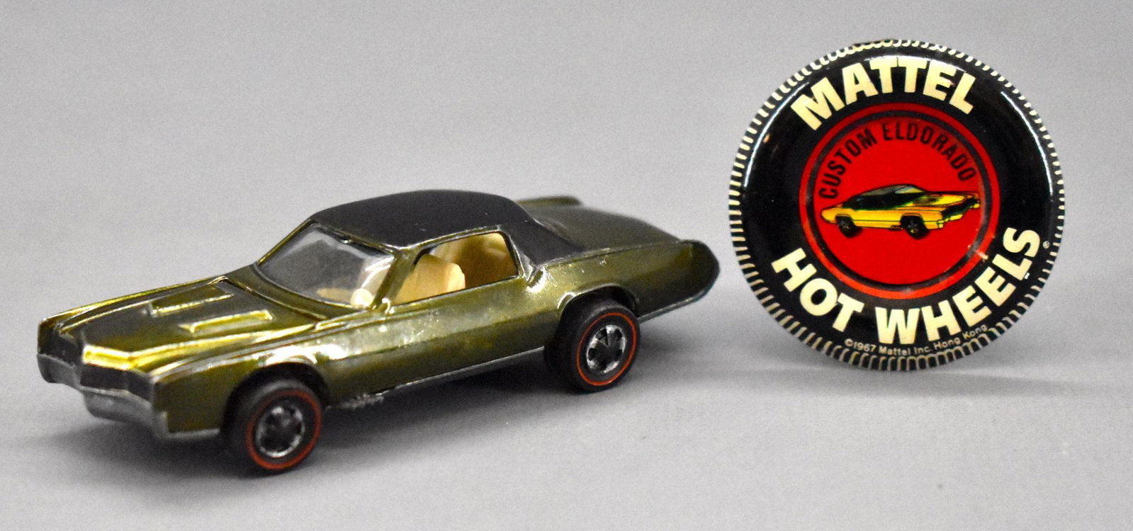 Redline Hot Wheels olive US Custom Eldorado: Redline Hot Wheels olive US Custom Eldorado with original metal button. Car is very clean with minor paint wear and toning with a dullish gunmetal base as seen in the photos.