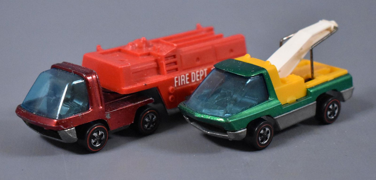 Two Original Redline Hot Wheels Heavyweights: Two Original Redline Hot Wheels Heavyweights to include a green Tow Truck and a red Fire truck that is missing the ladders as seen in the photos.