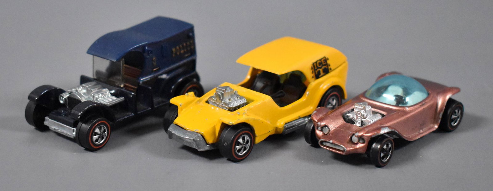 Three Original Redline Hot Wheels die cast cars: Three Original Redline Hot Wheels die cast cars to include HK copper Beatnik Bandit, yellow enamel Ice-T and paddy wagon, as seen in the photos.