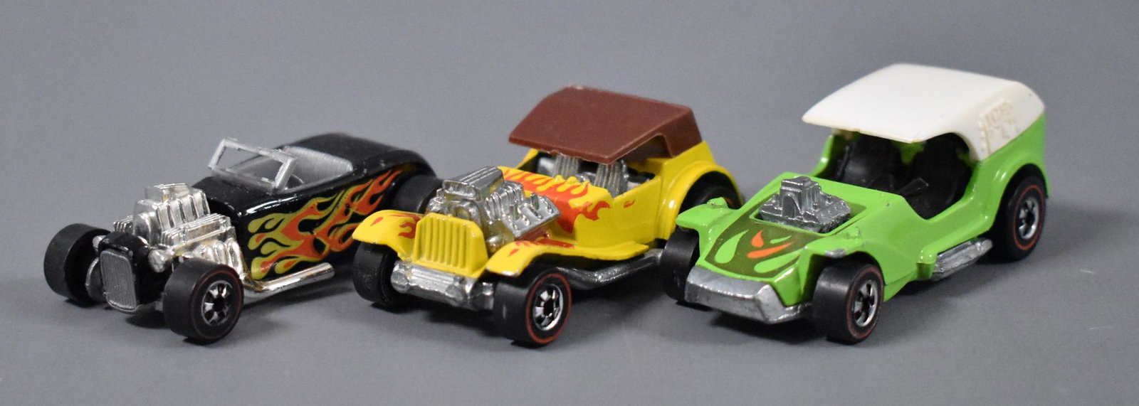 Three Original Redline Hot Wheels Flying Colors hot rod: Three Original Redline Hot Wheels hot rod die cast cars to include Street Rodder with a pinched window frame, Sir Rodney Roadster and Ice-T, all with play wear as seen in the photos.