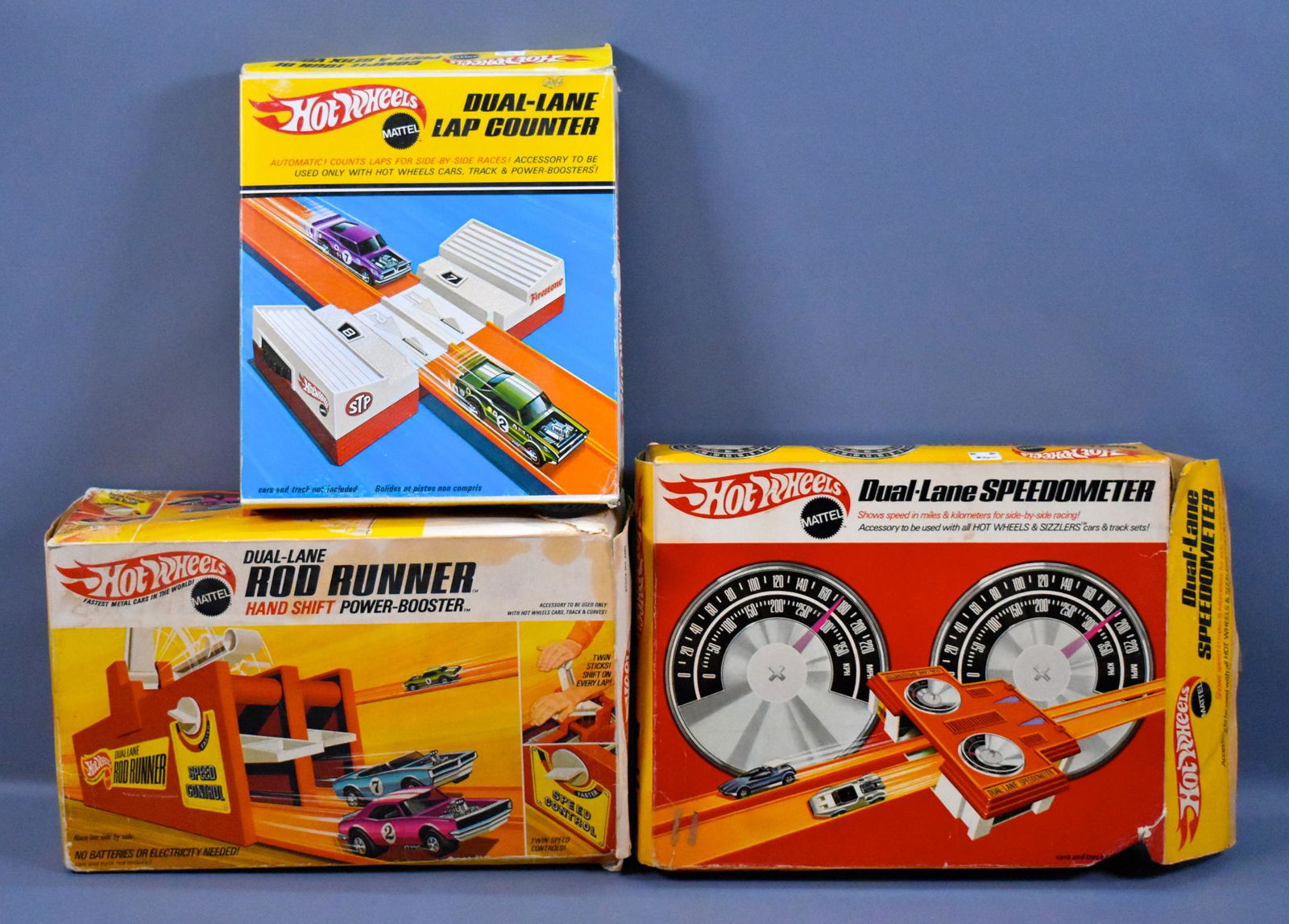 Three Redline Hot Wheels era track accessory pieces in: Three Redline Hot Wheels era track accessory pieces in original boxes to include dual lane Rod Runner, Dual lane Speedometer and Canadian box Dual Lane lap counter, all very good to excellent conditio