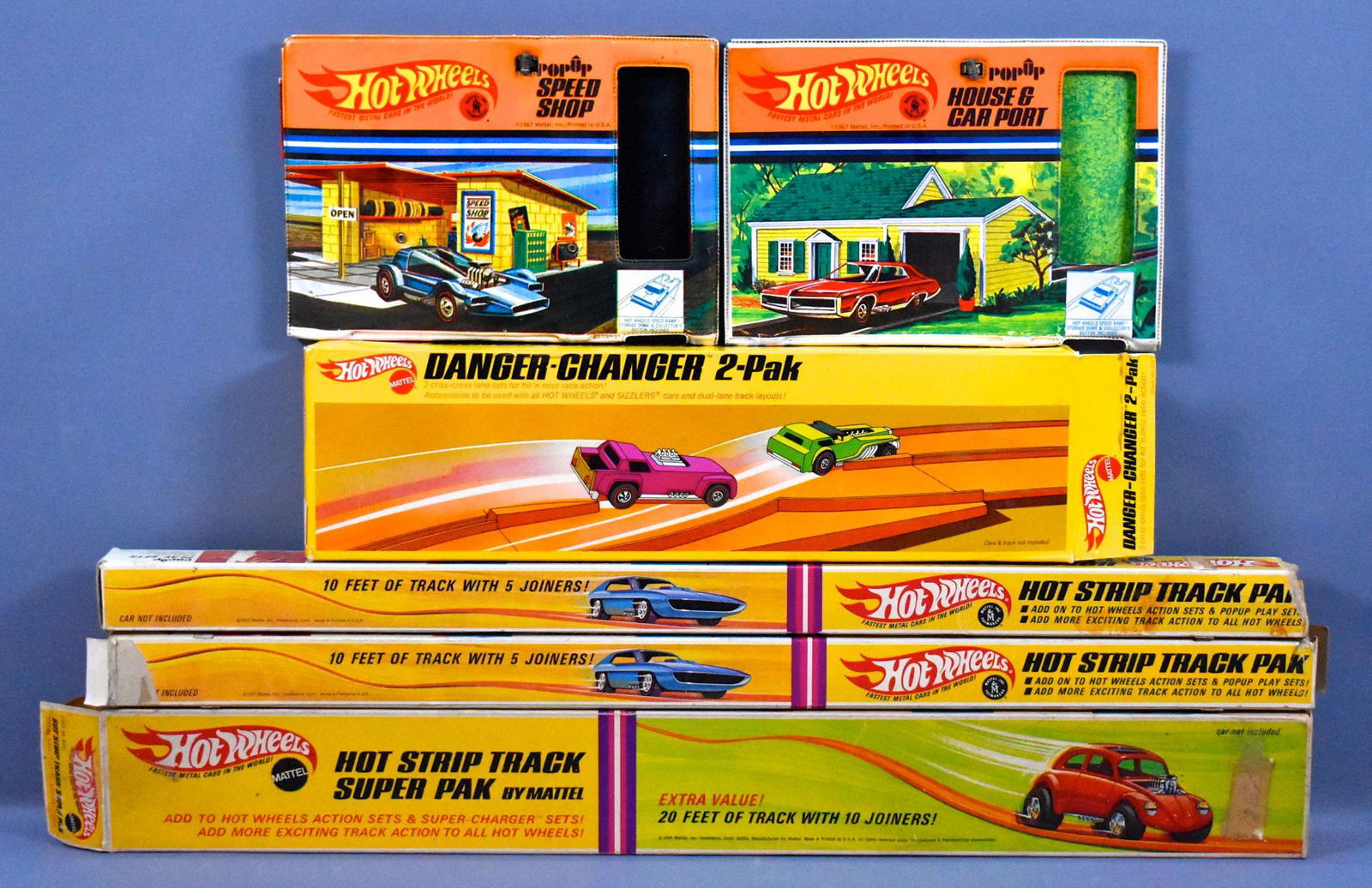 Four Redline Hot Wheels era track accessory pieces in: Four Redline Hot Wheels era track accessory pieces in original boxes to include two Hot Strip Track paks, Hot Strip Track Super pak, Danger Changer 2-Pak and two pop-up cases that are missing the blis