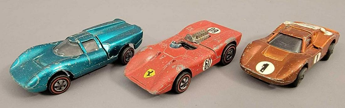 Group of 3 Redline Hot Wheels Lola Ferrari and Ford: Group of 3 Redline Hot Wheels Lola Ferrari and Ford Mark IV. Group includes an aqua Lola, enamel red ferrari and orange Ford Mark IV. All are complete with good hatches but are in filler condition. As