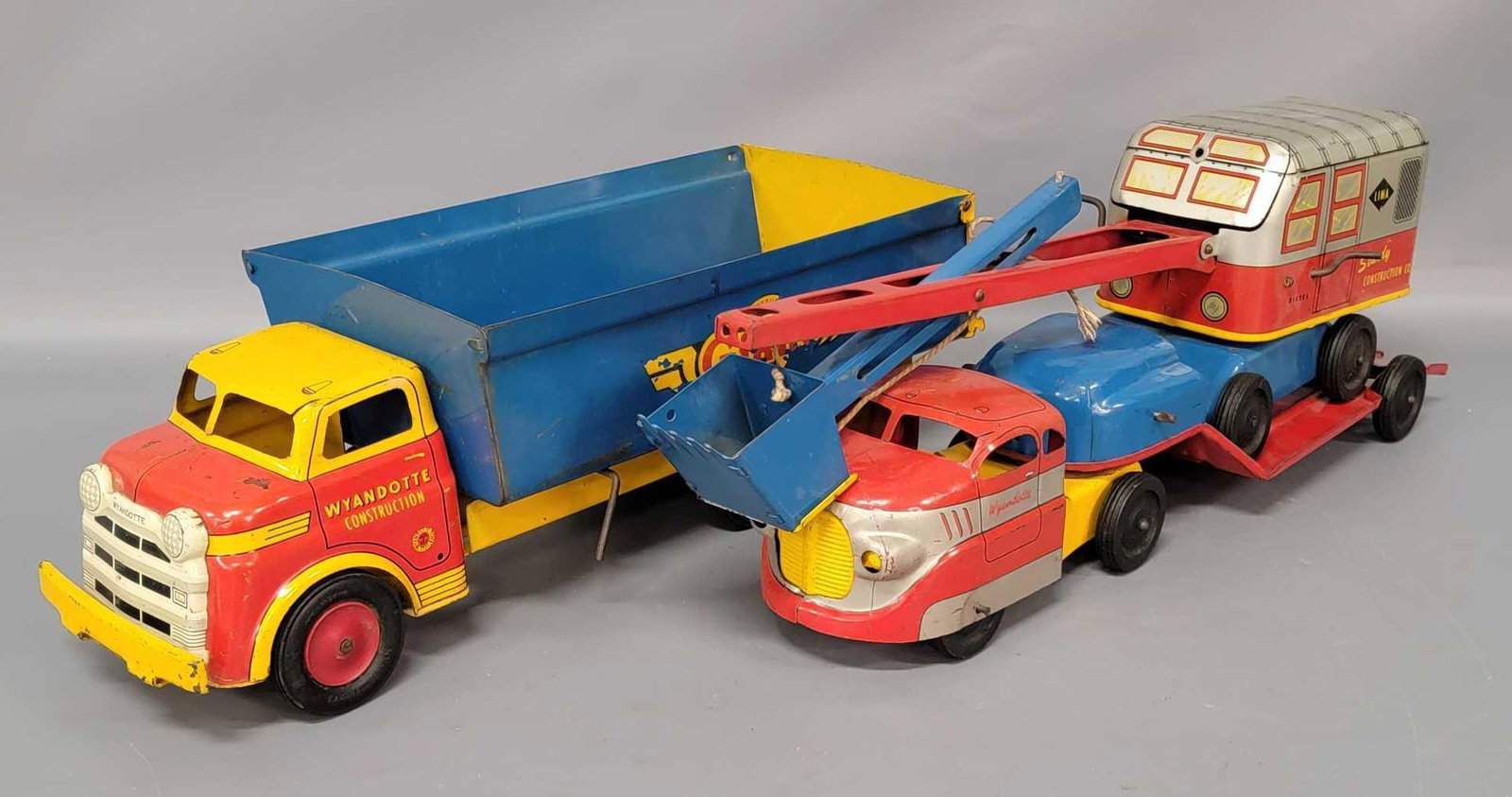 Wyandotte Construction Dump Truck, Flatbed Hauler, and: Wyandotte Construction Dump Truck, Flatbed Hauler, and Shovel. All pieces are good with some paint wear and scratches throughout. The dumper is missing the rear lever of the bed. The shovel controls w